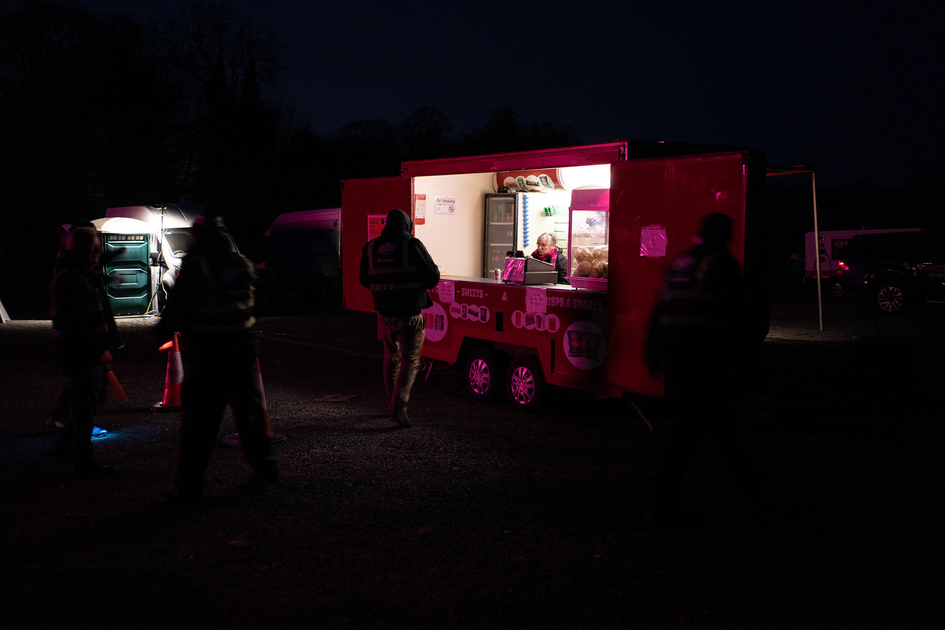 People queue at a safe distance to purchase snacks from the only vending stall on site. Dublin, Ireland - March 23, 2020.