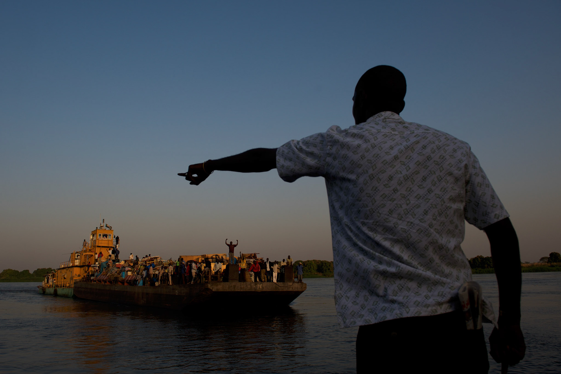 A man points instructions to the crew of a barge carrying hundreds of South Sudanese arriving in Juba ahead of the referendum for independence of South Sudan.