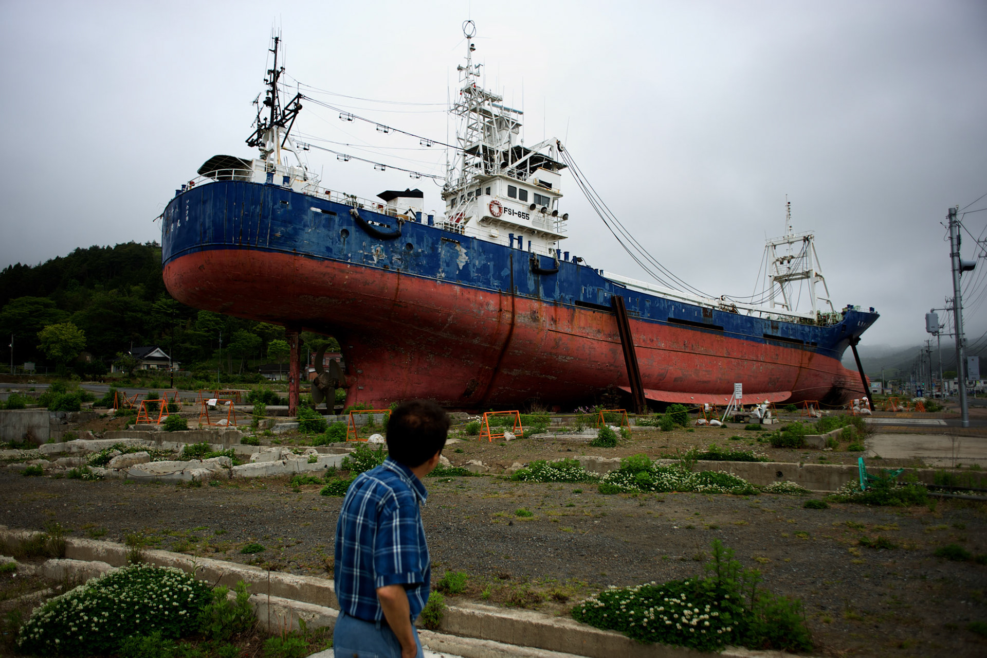 May 29, 2013 - Kesenuma, Japan: A bystander looks at a large vessel, washed away by the 2011 tsunami, grounded in what used to be a residential neighbourhood in central Kesennuma, northeastern Japan. (Paulo Nunes dos Santos)