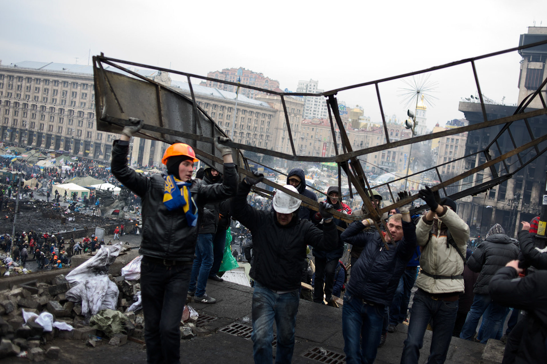 KIEV, UKRAINE - February 20, 2014: Anti-government protestors carry scrap metal to be used in new defensive barricades, as violent clashes between protestors and riot police happen outside Independence Square in central Kiev. The riot police responded to the advance with gunfire that, according to the opposition, killed at least 70 and as many as 100 people. The drastic escalation of the three-month-old Ukraine crisis left the country reeling from the most lethal violence in decades. CREDIT: Paulo Nunes dos Santos