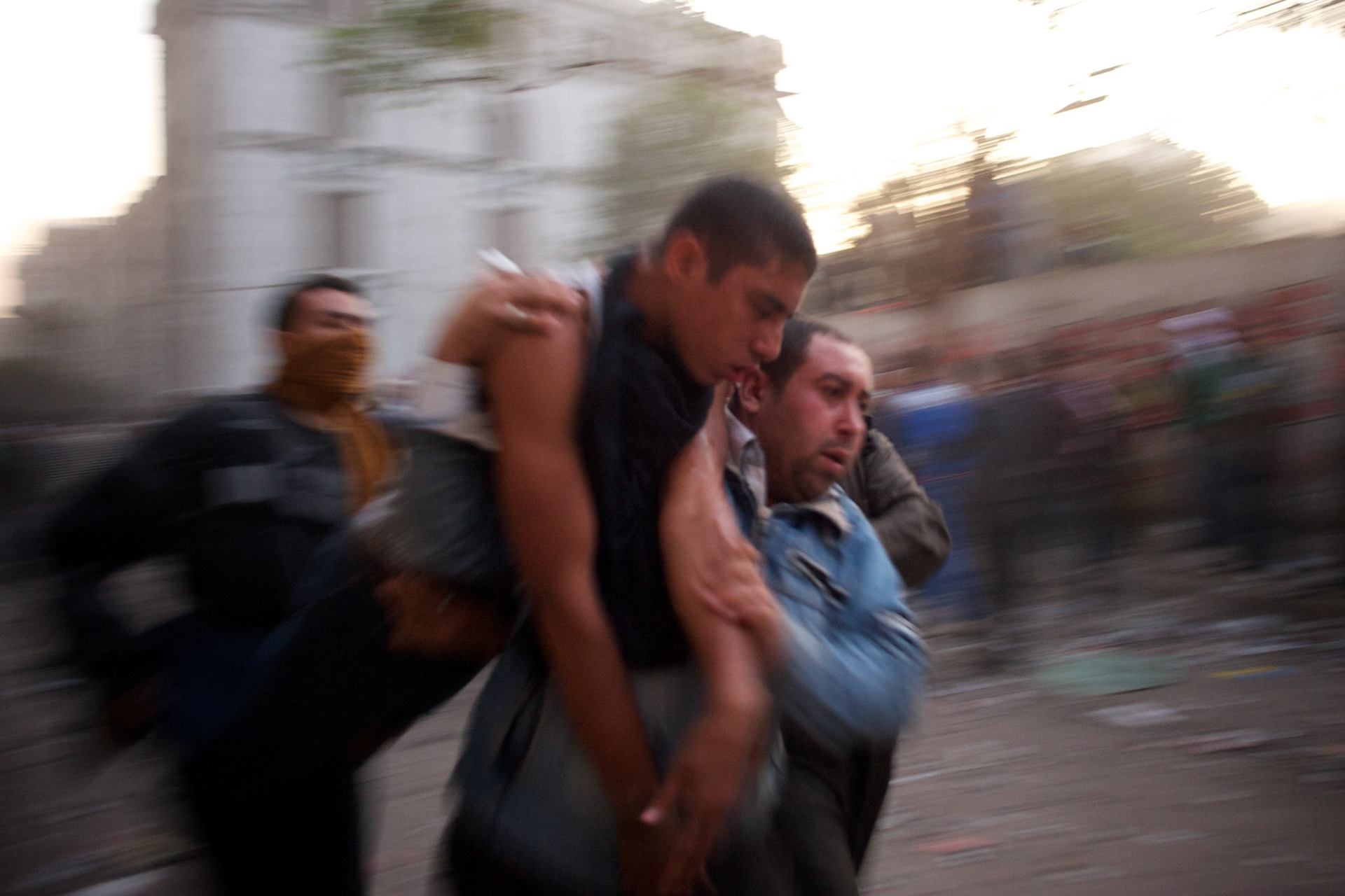 People carry an injured protestor during violent clashes with the security forces in central Cairo.