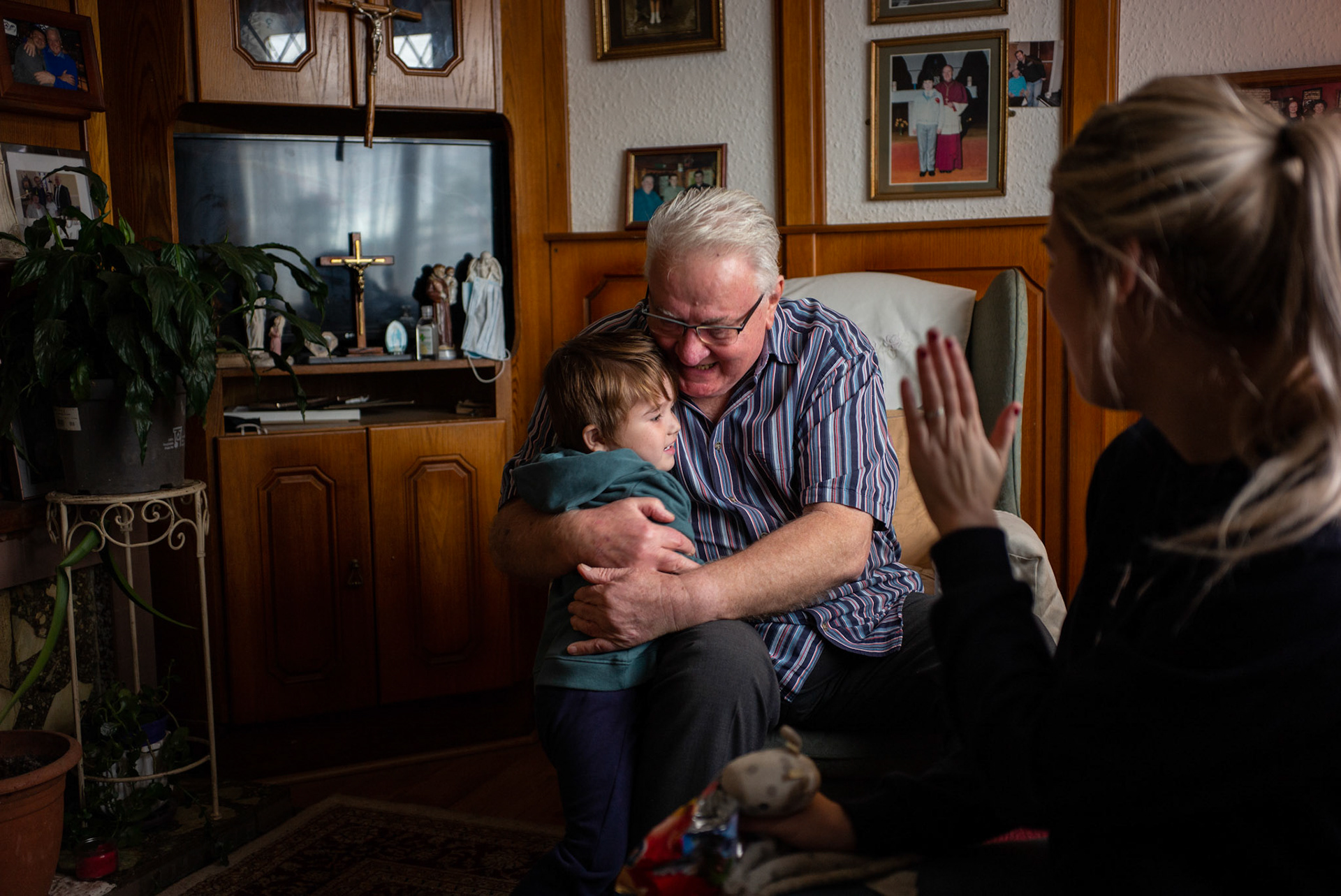 PULLOUGH, IRELAND - NOVEMBER 14, 2021: Faith Healer Joe Gallagher, during the first treatment session on a 3 year old boy with croup cough, at his house in Pullough, a small village in County Offaly, Ireland. The child, Harley from Birr, a town nearby, was brought in by his mother who heard about Joe’s healing powers through word of mouth.With touch and prayers, every Sunday Joe gives ‘the cure’ to people looking for treatment for various ailments. As a seventh son, Joe, who is also a former monk, is known for having faith healing powers since young age.Faith healers have been around since antiquity and many Irish believe that certain people have God-given gifts to cure diseases. According to old Irish folklore, the seventh son of a seventh son has special healing powers, however, others get ‘the cure’ passed on to them by a parent or an older relative. CREDIT: Paulo Nunes dos Santos for The New York Times