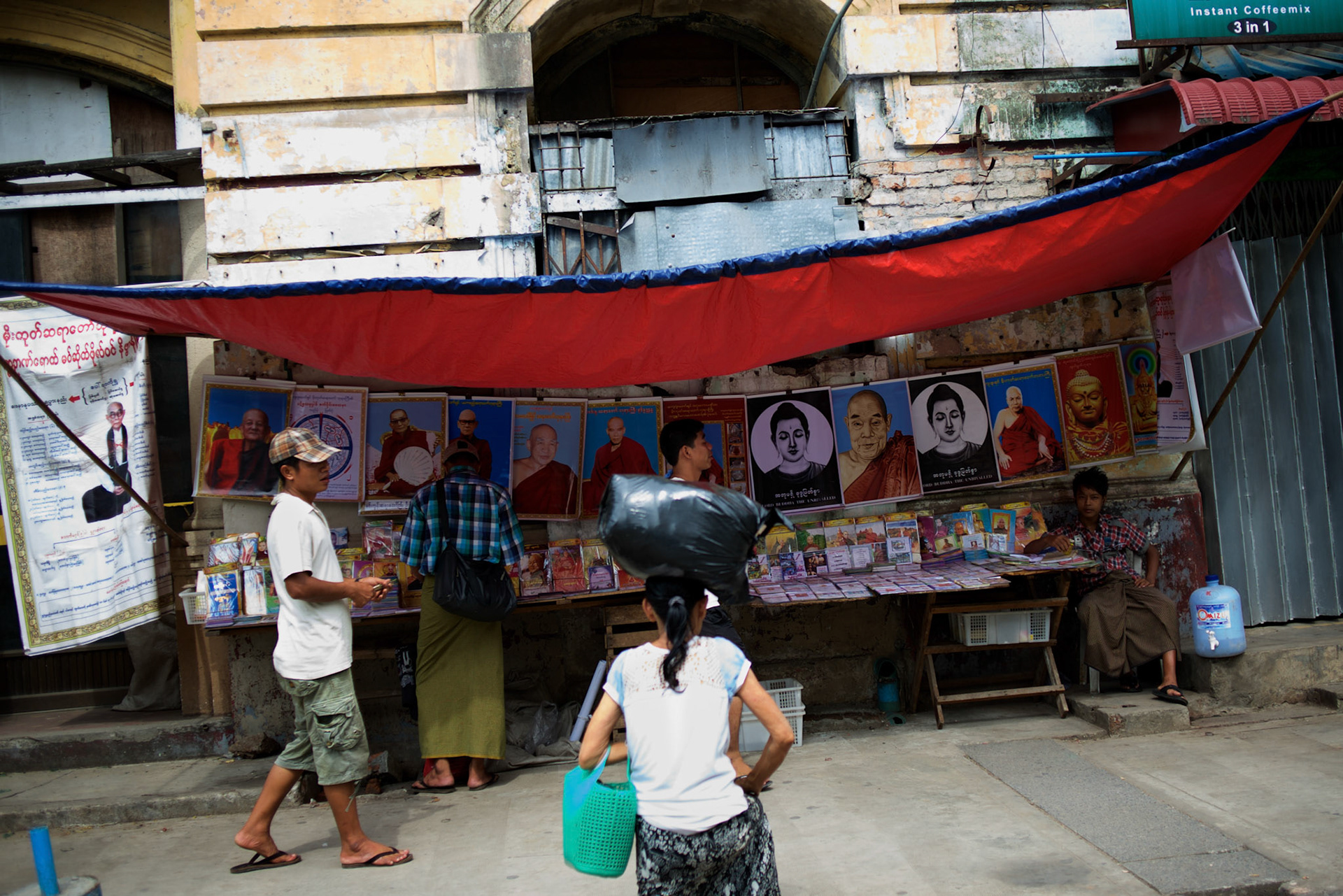 May 18, 2013 - Yangon, Myanmar: Locals pass by a street stall selling religious portraits in central Yangon. CREDIT: Paulo Nunes dos Santos