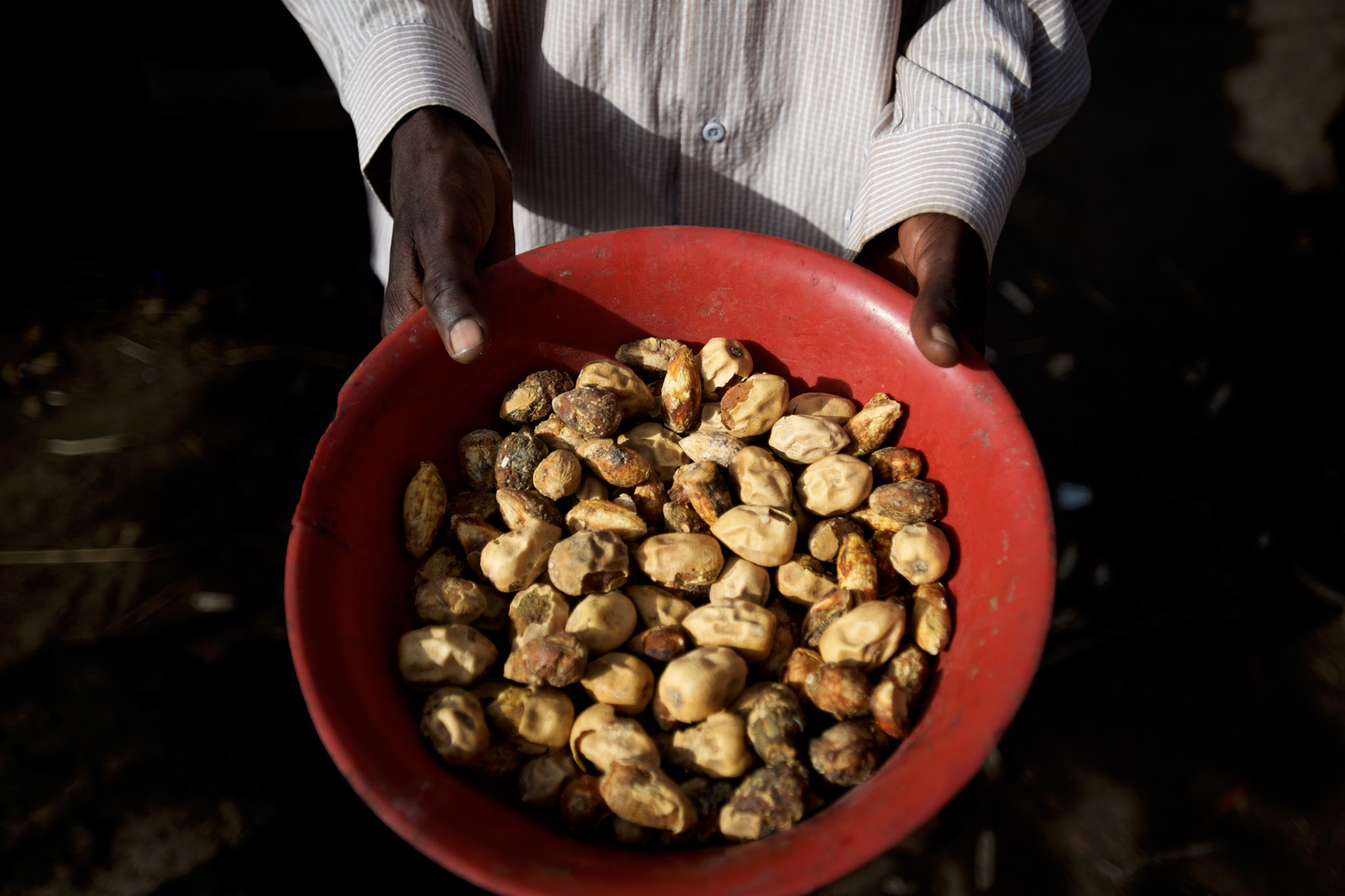 A local resident shows the food available for the whole family at their improvised home in the caves outside Buram village in South Kordofan's Nuba Mountains.