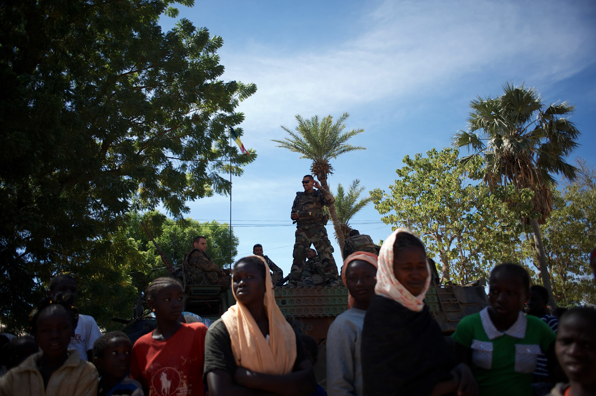 January 21, 2013 - Diabaly, Mali: Locals stand near french military forces take guard in central Diabaly, a day after Mali government troops regain control of the city. Diabaly was under islamist militants control since the 14th of January.Several insurgent groups have been fighting a campaign against the Malian government for independence or greater autonomy for northern Mali, an area known as Azawad. The National Movement for the Liberation of Azawad (MNLA), an organisation fighting to make Azawad an independent homeland for the Tuareg people, had taken control of the region by April 2012.The Malian government pledge to the French army to help the national troops to stop the rebellion advance towards the capital Bamako. The french troops started aerial attacks on rebel positions in the centre of the country and deployed several hundred special forces men to counter attack the advance on the ground. (Paulo Nunes dos Santos)