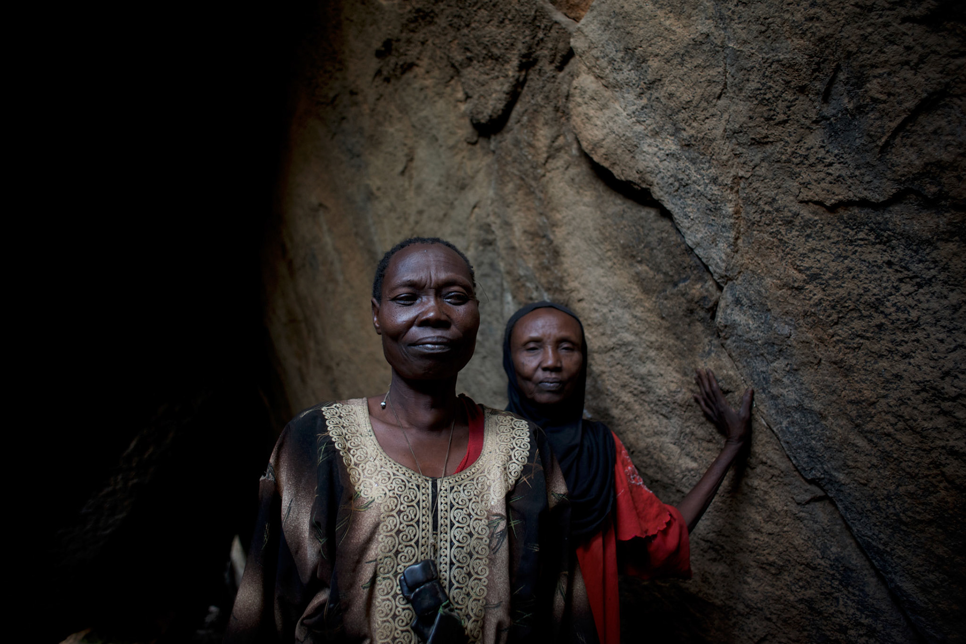 Nuba women take cover from possible bombardments by Sudan's Army Forces airplane in some caves near Buram village.