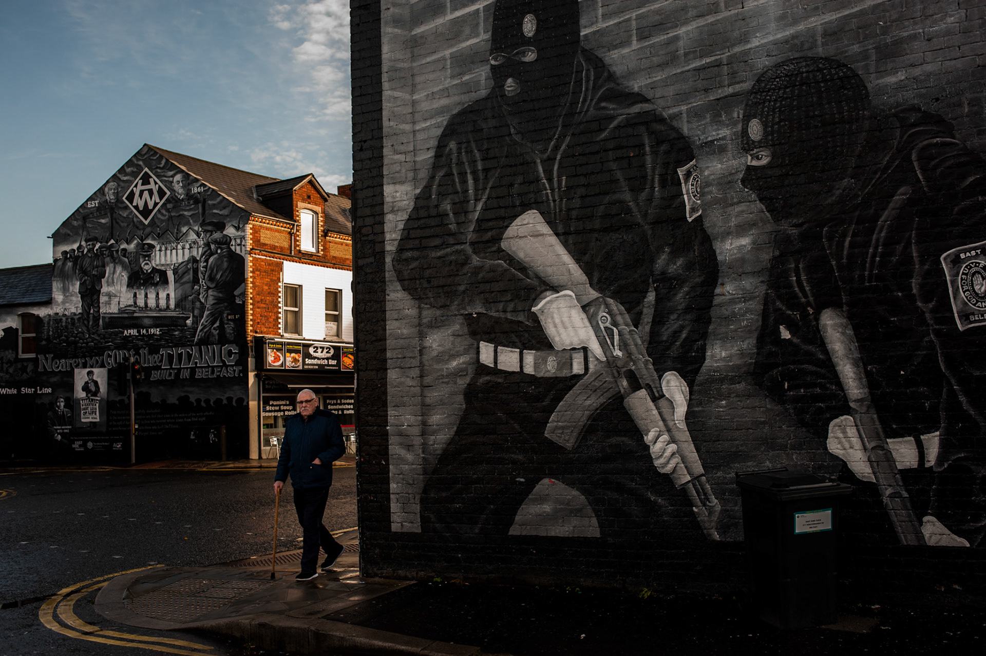 A man walks past a loyalist mural referencing the presence of the UDA paramilitary group on Newtownards Road, a predominantly Protestant and loyalist neighbourhood in East Belfast, Northern Ireland, on November 27, 2017.