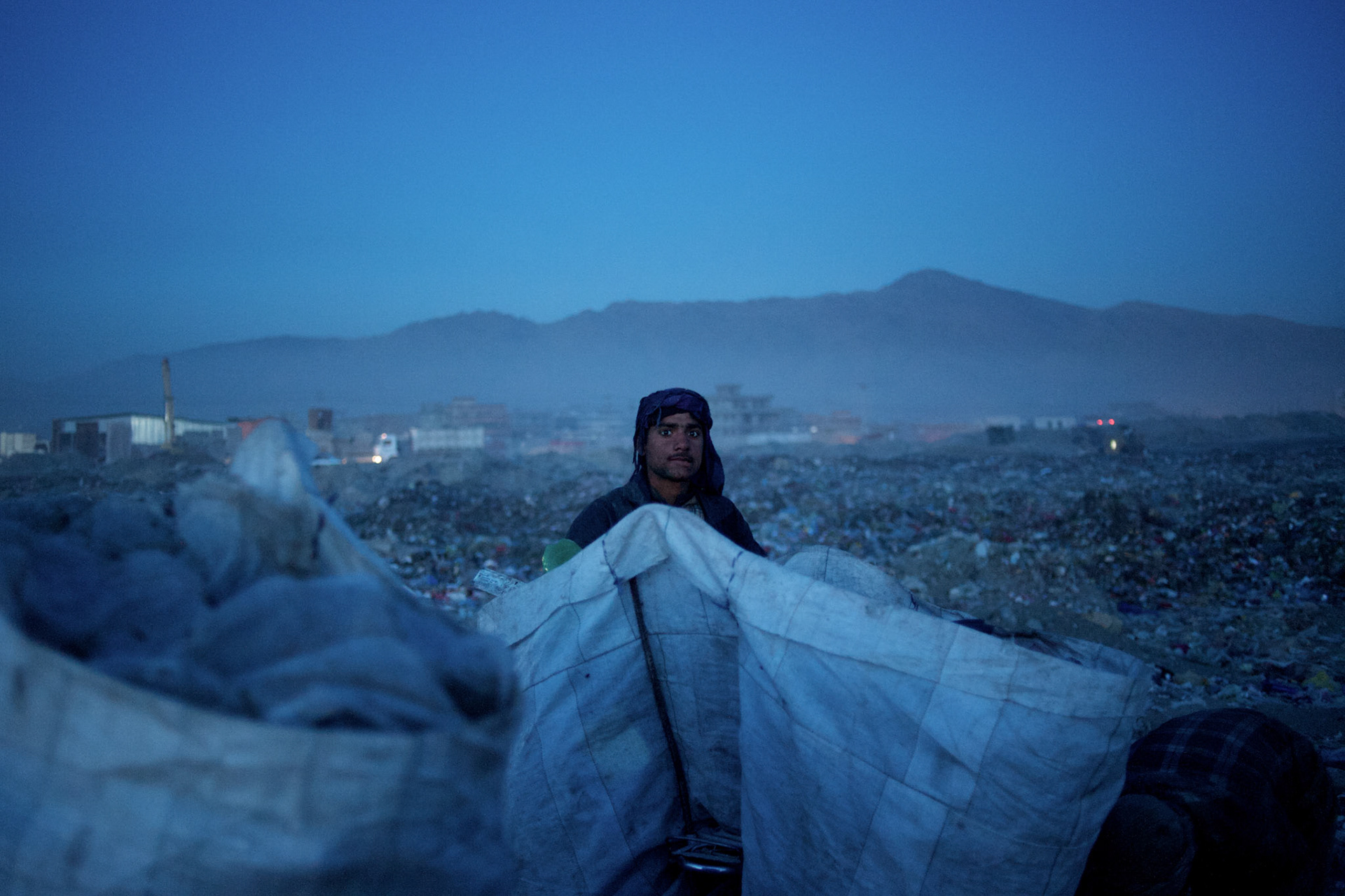 November 14, 2012 - Kabul, Afghanistan: An Afghan Pashtun boy, who said he was forced from the troubled province of Baglan due to threats from the Taliban, scavenges for recyclables at a garbage dump site in Kabul. (Paulo Nunes dos Santos)