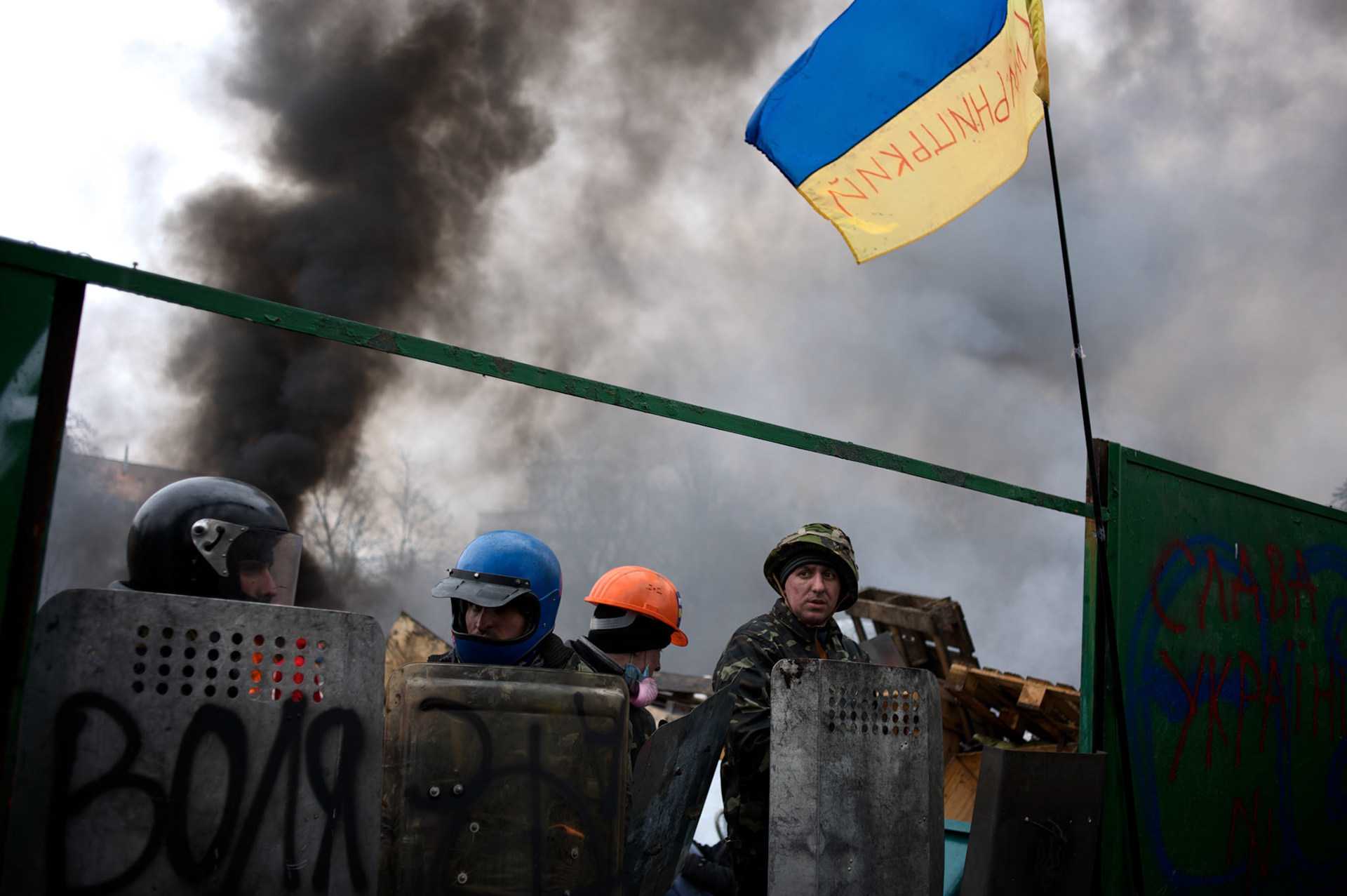KIEV, UKRAINE - February 20, 2014: Anti-government protestors take cover behind newly build barricades at the frontline where violent clashes were happening between protestors and riot police outside Independence Square in central Kiev. The riot police responded to the advance with gunfire that, according to the opposition, killed at least 70 and as many as 100 people. The drastic escalation of the three-month-old Ukraine crisis left the country reeling from the most lethal violence in decades. CREDIT: Paulo Nunes dos Santos
