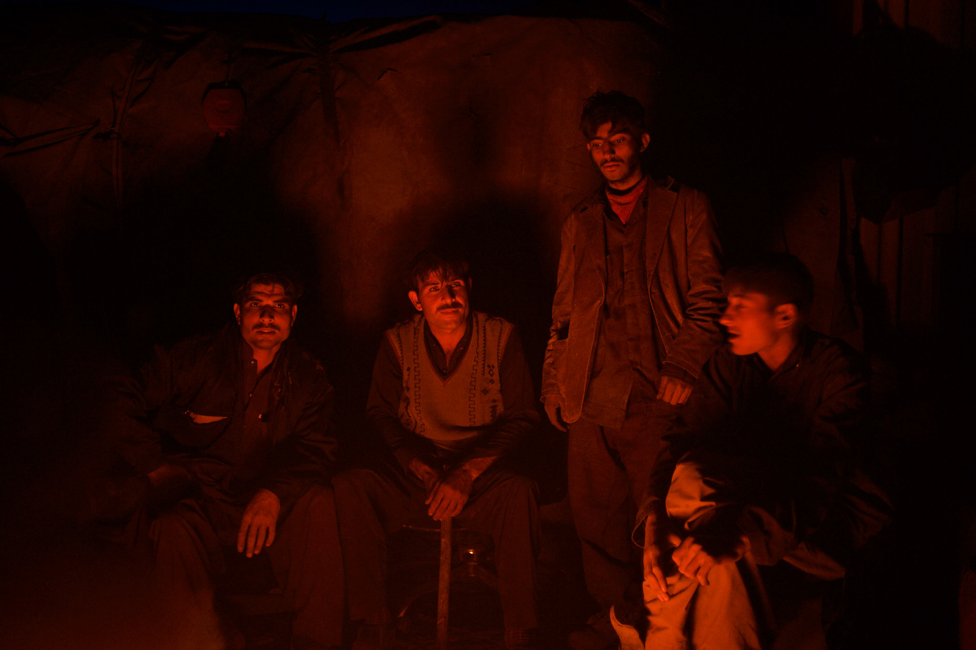 KABUL, AFGHANISTAN - NOVEMBER 14, 2012: Afghan boys sit around a fire after a long day scavenging for recyclables at a garbage dump site in the outskirts of Kabul.