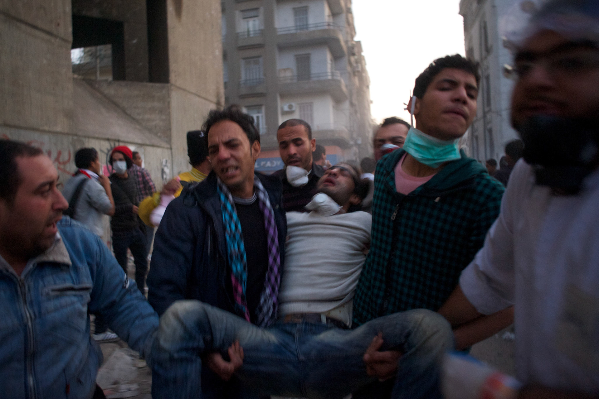 People carry an injured protestor during violent clashes with the security forces in central Cairo.