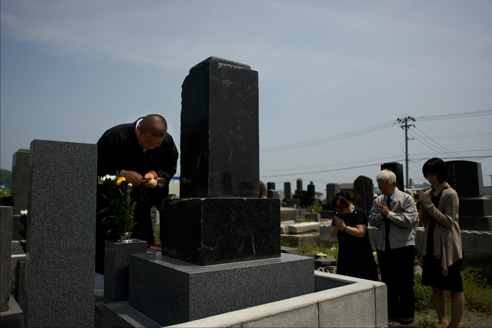 A family attend a religious ceremony, at local cemetery in Ishinomaki, in memory of a relative who lost his life during the  devastating tsunami that hit the east coast of Japan in 2011.