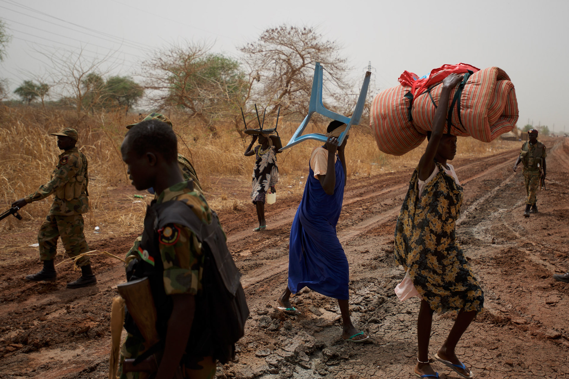SPLA soldiers walk by civilians fleeing combats between the South Sudan military and the neighbouring Sudan over the control of oil fields in a disputed border area near Bentiu.
