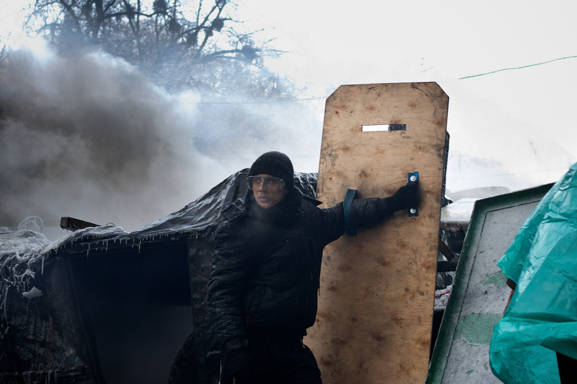 January 25, 2014 - Kiev, Ukraine: A anti-government protestor uses a homemade shield to protect himself from the riot police water canons at a barricade outside the Dynamo Kiev stadium, near the Independence Square in central Kiev. (Paulo Nunes dos Santos)