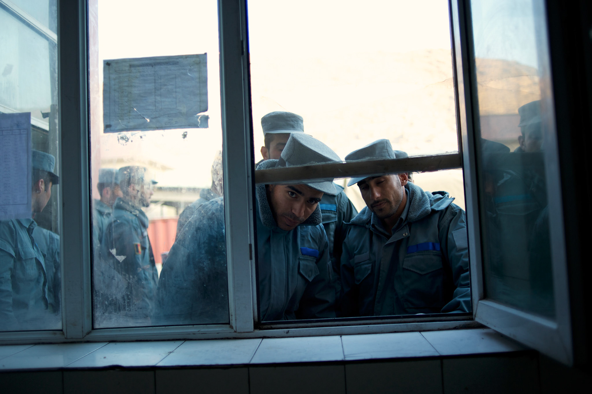 Afghan National Police (ANP) cadets wait for the distribution of hot milk outside the kitchen of the Afghan Nacional Police Academy in Kabul.