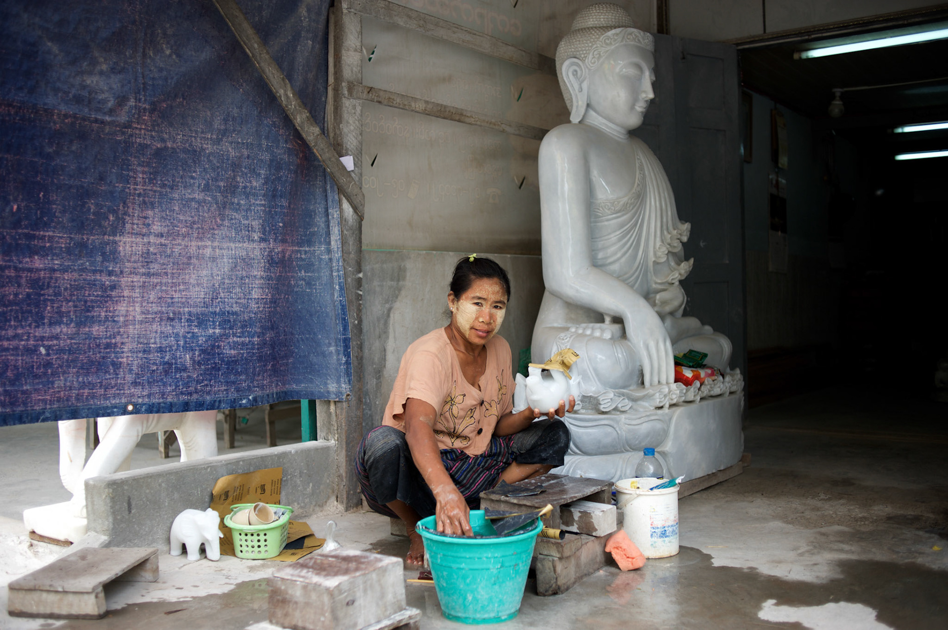 May 14, 2013 - Mandalay, Myanmar: A local woman sands a buddha statue in a traditional workshop, in Mandalay, dedicated to the production of religious paraphernalia. CREDIT: Paulo Nunes dos Santos