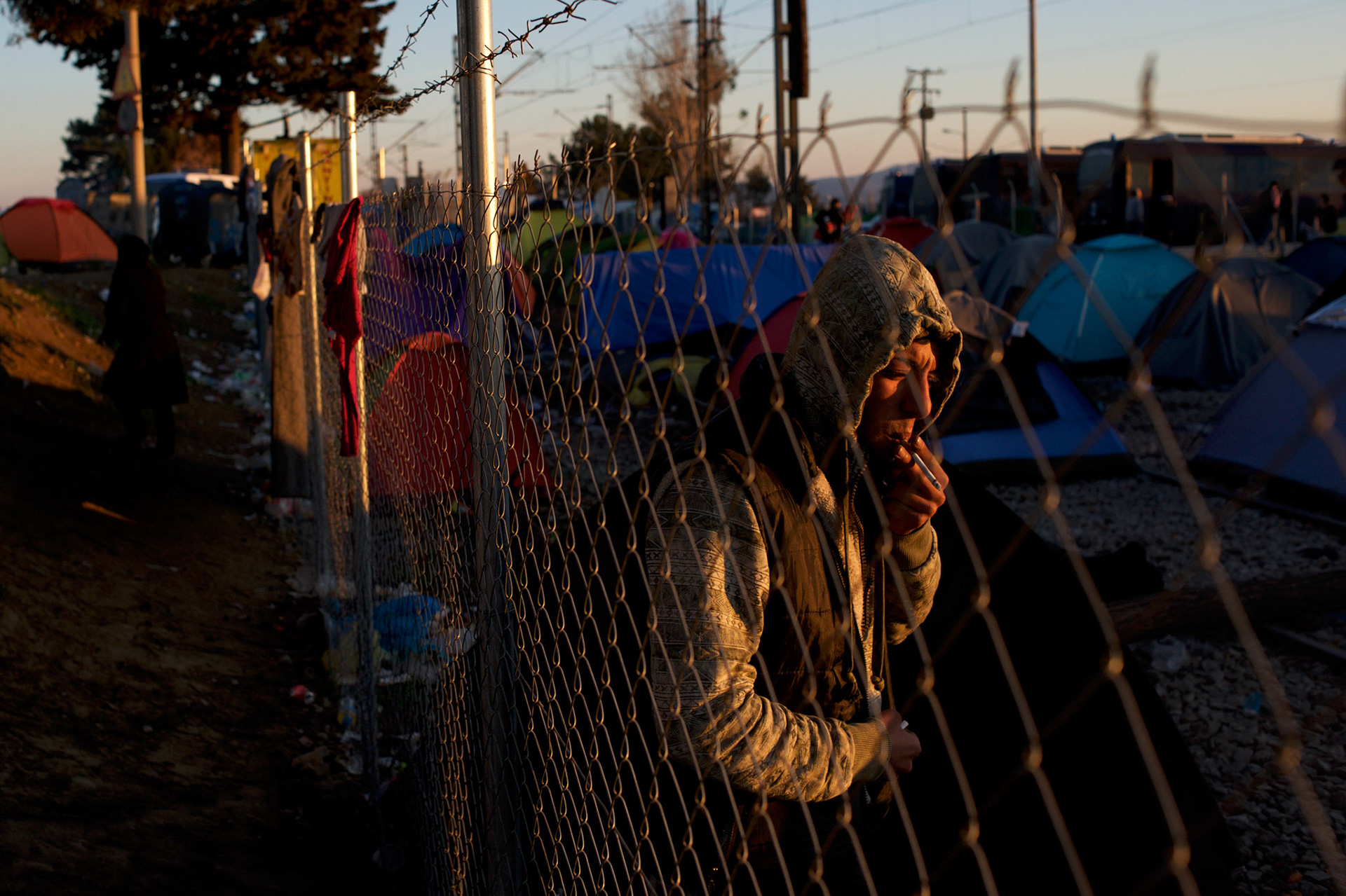 A Syrian refugee is seen smoking a cigaret beside his tent set up on the train tracks at the border between Greece and Macedonia in Idomeni, Greece. Around 13,000 migrants and refugees, mostly from the Middle East and African nations, are believe to be stranded here awaiting a chance to proceed their journey towards Germany and other northern European countries.