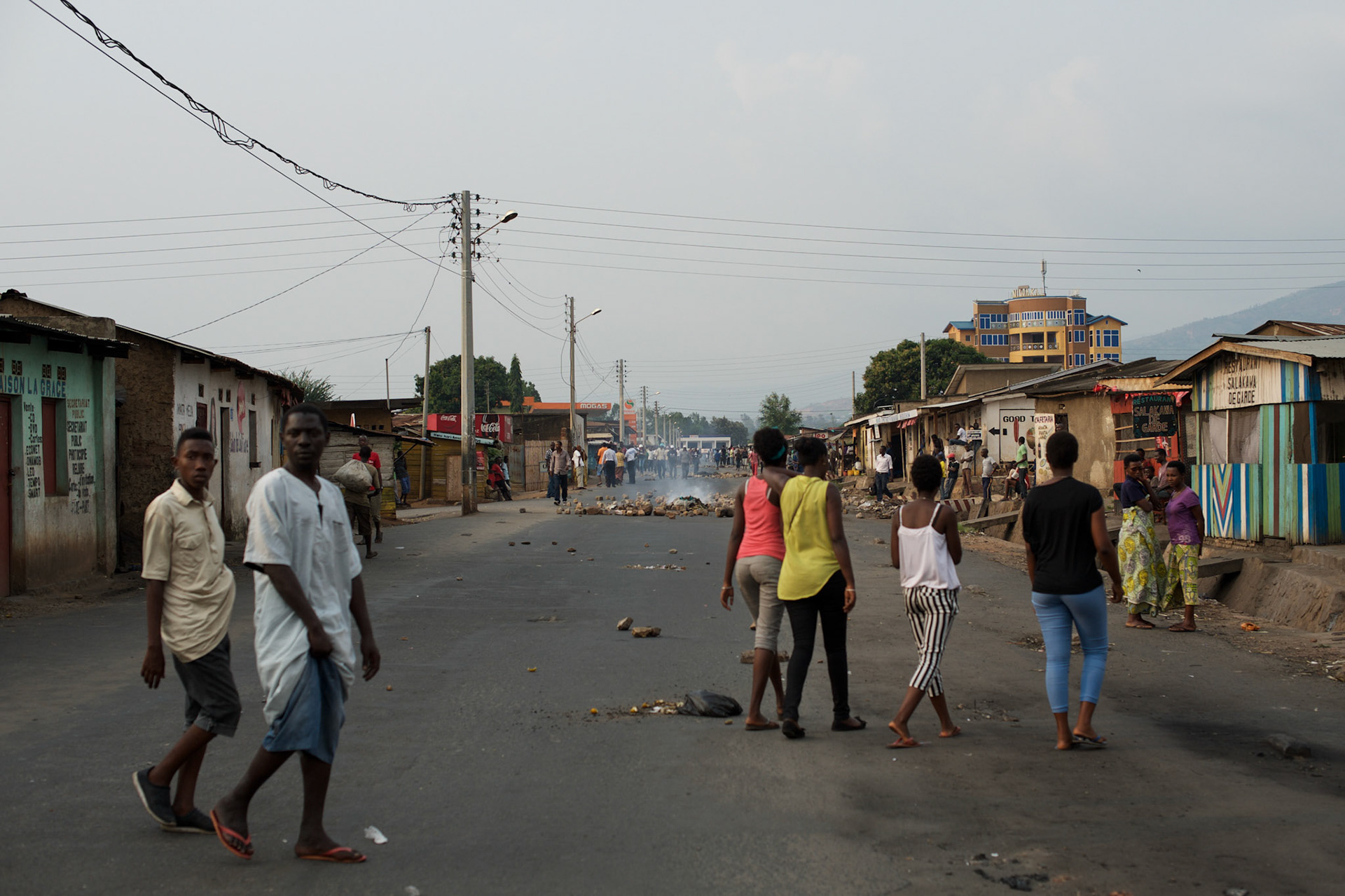 Locals wander the streets of Niykabiga in Bujumbura, moments after the National Police moved in to the area to disperse a group of protestors who blocked the road to prevent a candidate from a political party aligned with the ruling party CNDD-FDD, to rally in neighbourhood.
