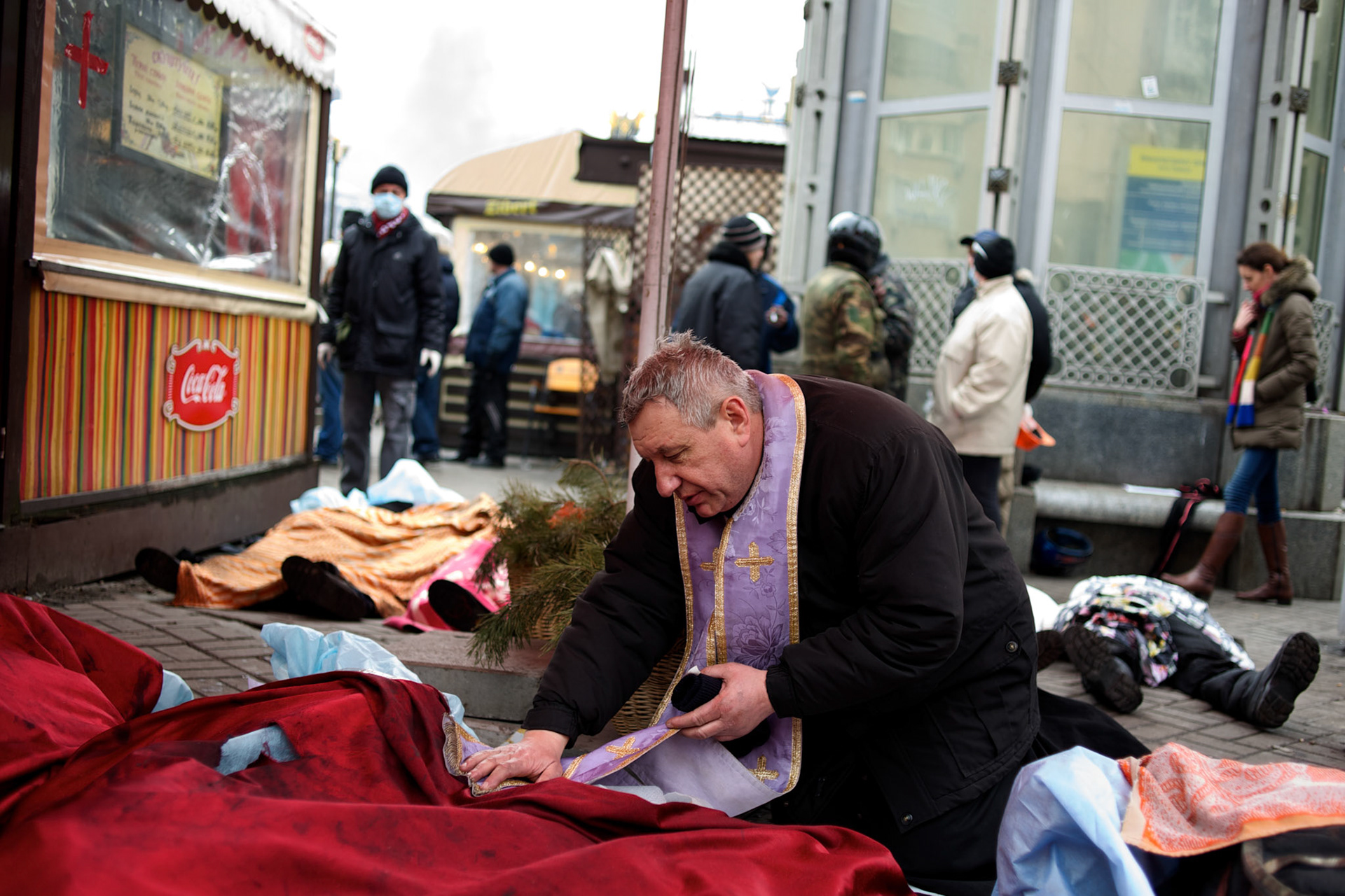 KIEV, UKRAINE - February 20, 2014: An Orthodox priest blesses the bodies of anti-government protestors shot dead during an advance on police lines outside the Independence Square in central Kiev. The riot police responded to the advance with gunfire that, according to the opposition, killed at least 70 and as many as 100 people. The drastic escalation of the three-month-old Ukraine crisis left the country reeling from the most lethal violence in decades. CREDIT: Paulo Nunes dos Santos