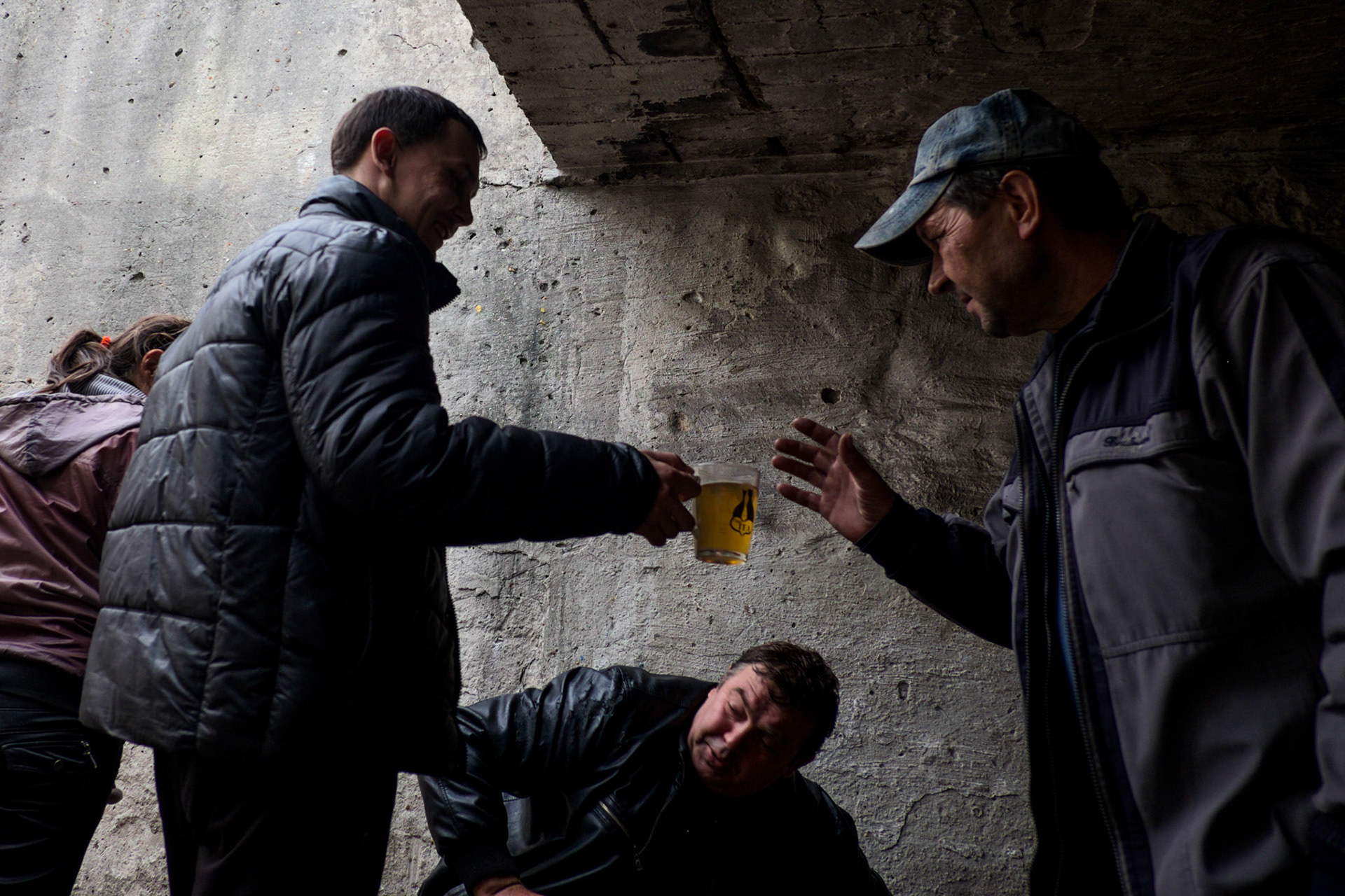 People displaced by the war share a cup of tea at the entrance to a bomb shelter in Petrovskiy district, Donetsk.