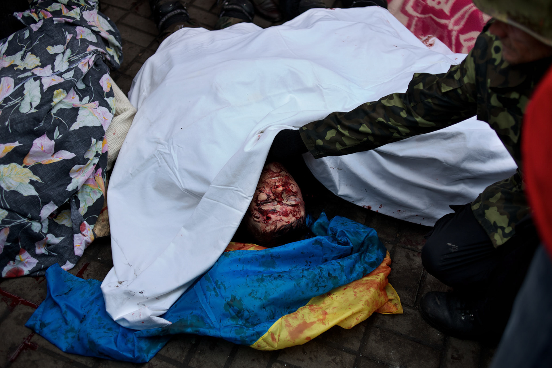 KIEV, UKRAINE - February 20, 2014: People check the bodies of anti-government protestors shot dead during an advance on police lines outside the Independence Square in central Kiev. The riot police responded to the advance with gunfire that, according to the opposition, killed at least 70 and as many as 100 people. The drastic escalation of the three-month-old Ukraine crisis left the country reeling from the most lethal violence in decades. CREDIT: Paulo Nunes dos Santos