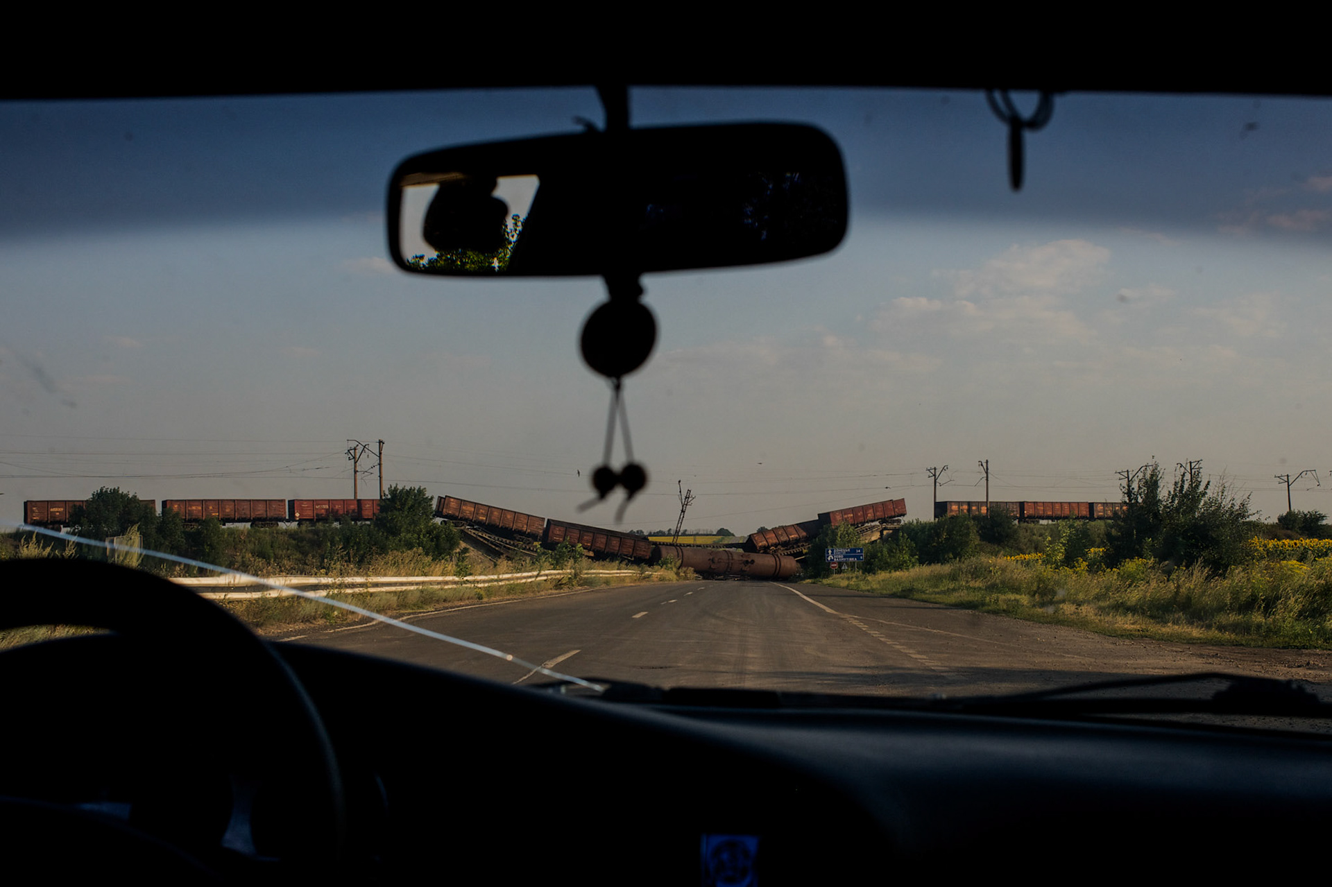 A road to Donetsk, blocked by a bombed railway bridge and a train.