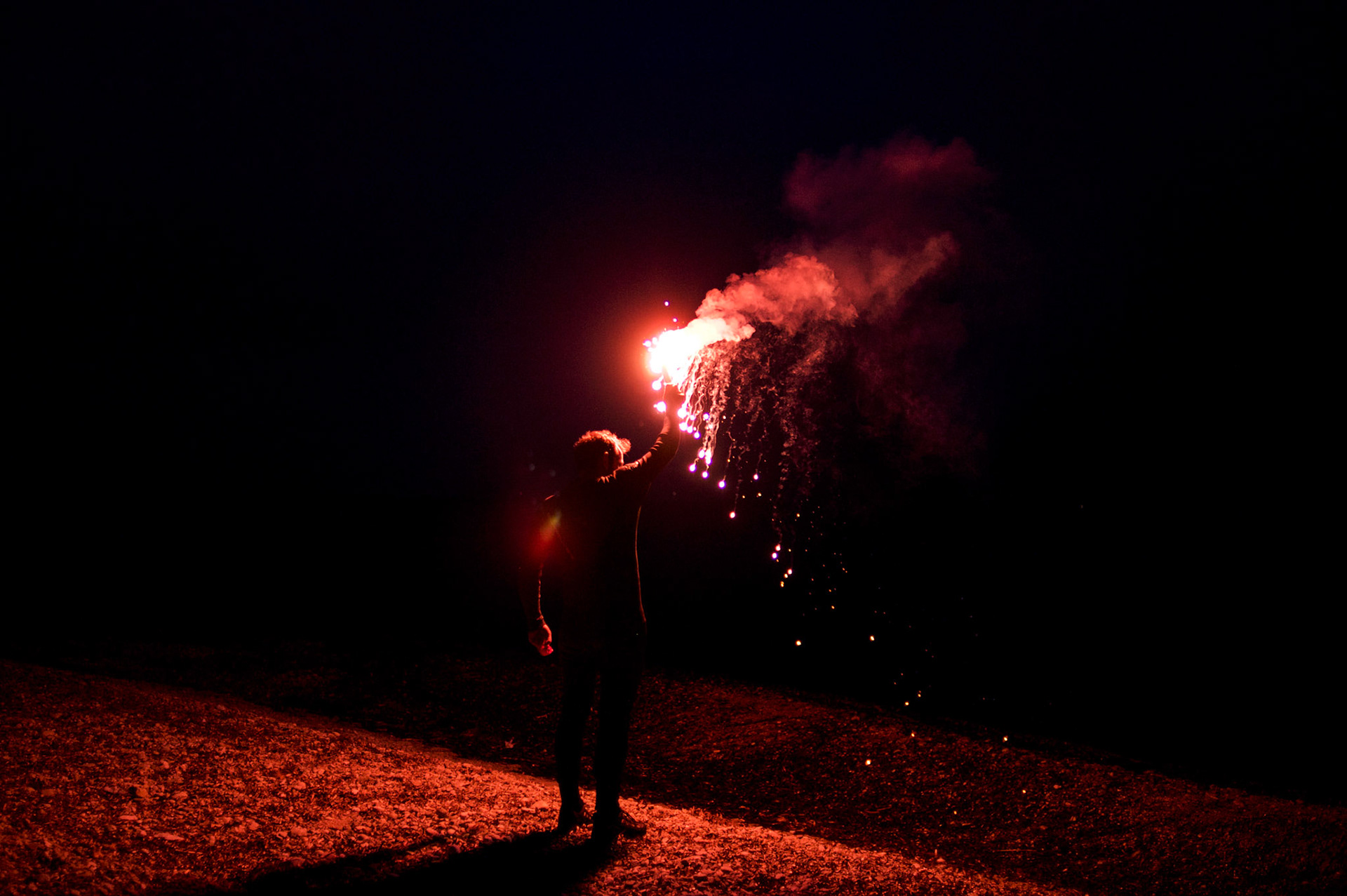 A spanish volunteer lights an emergency flare to call the attention of Syrian and Afghan migrants approaching the coast of the greek island of Lesbos on a precarious dinghy.
