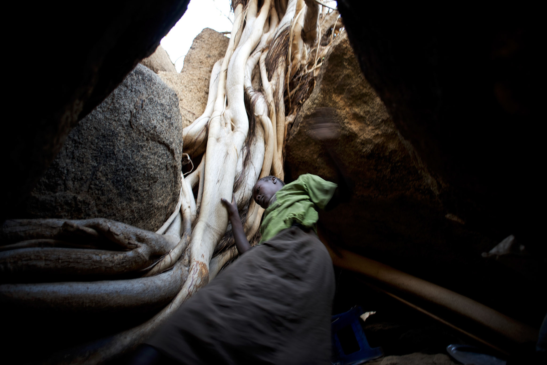 A Nuba woman takes cover, from possible bombardments by Sudan's Army Forces airplane, in some caves near Buram village.