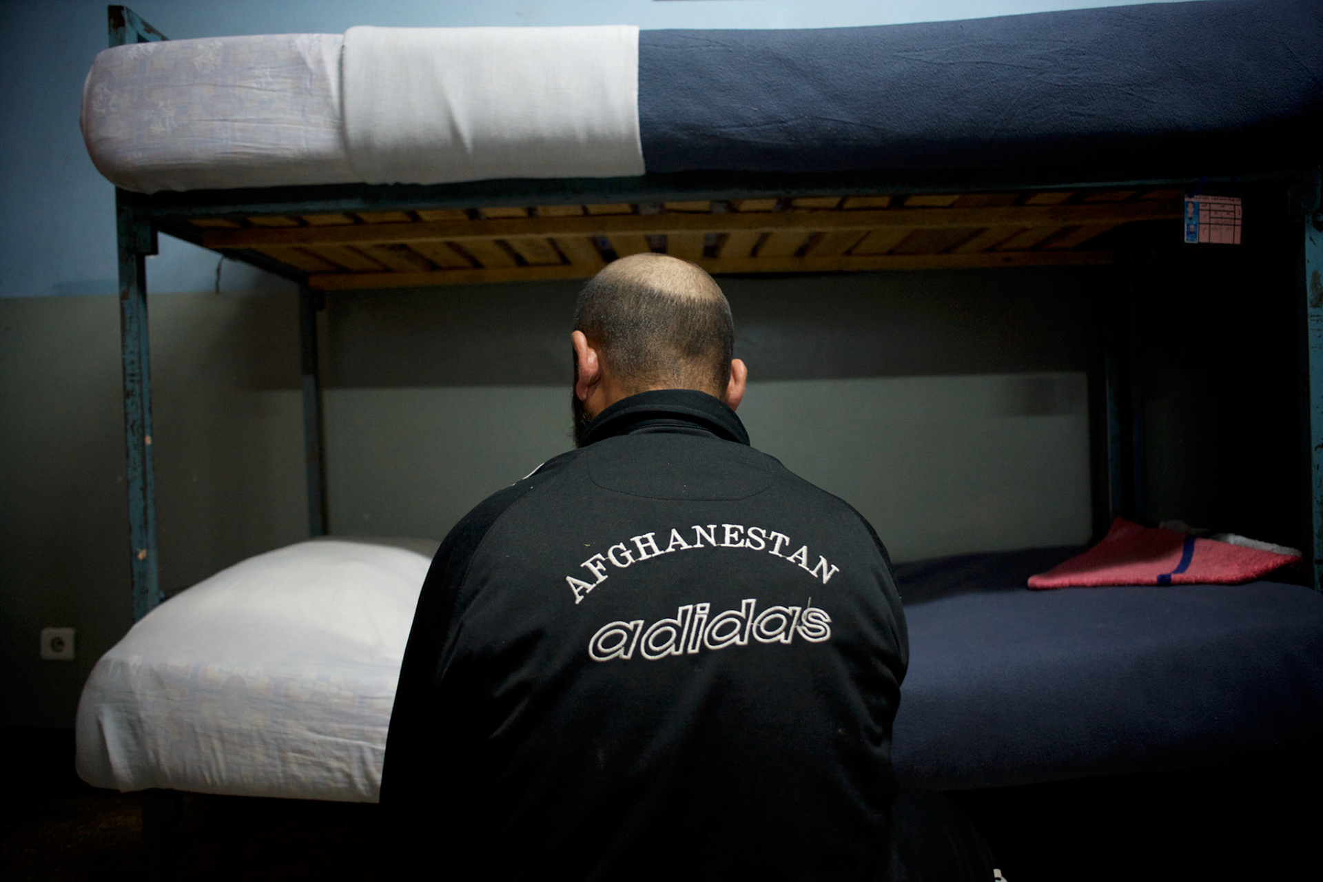 An Afghan National Police (ANP) cadet stands beside is bed at a dorm in the Afghan Nacional Police Academy in Kabul.
