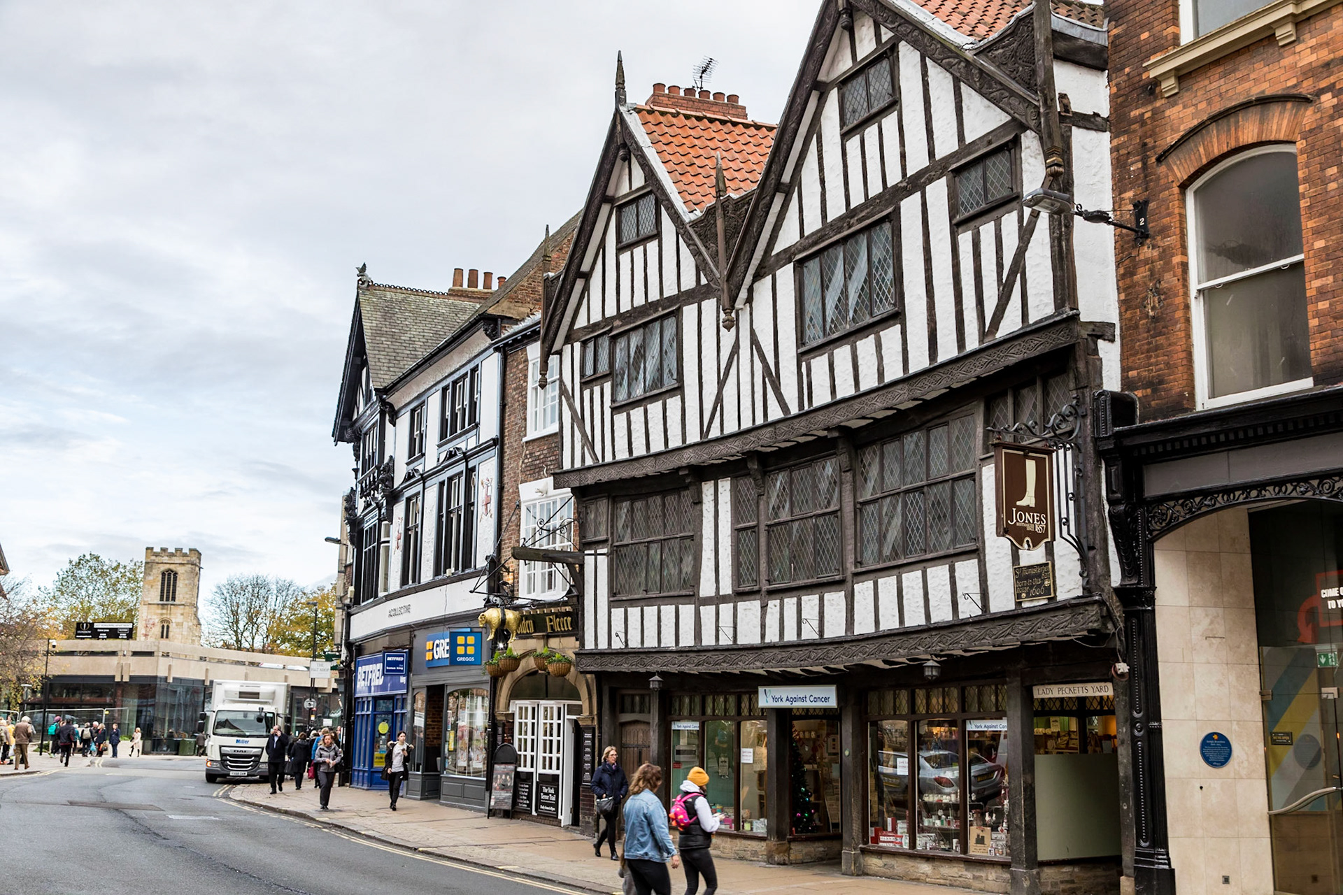 Along The Pavement, with the historic Golden Fleece public house and the Herbert's House.