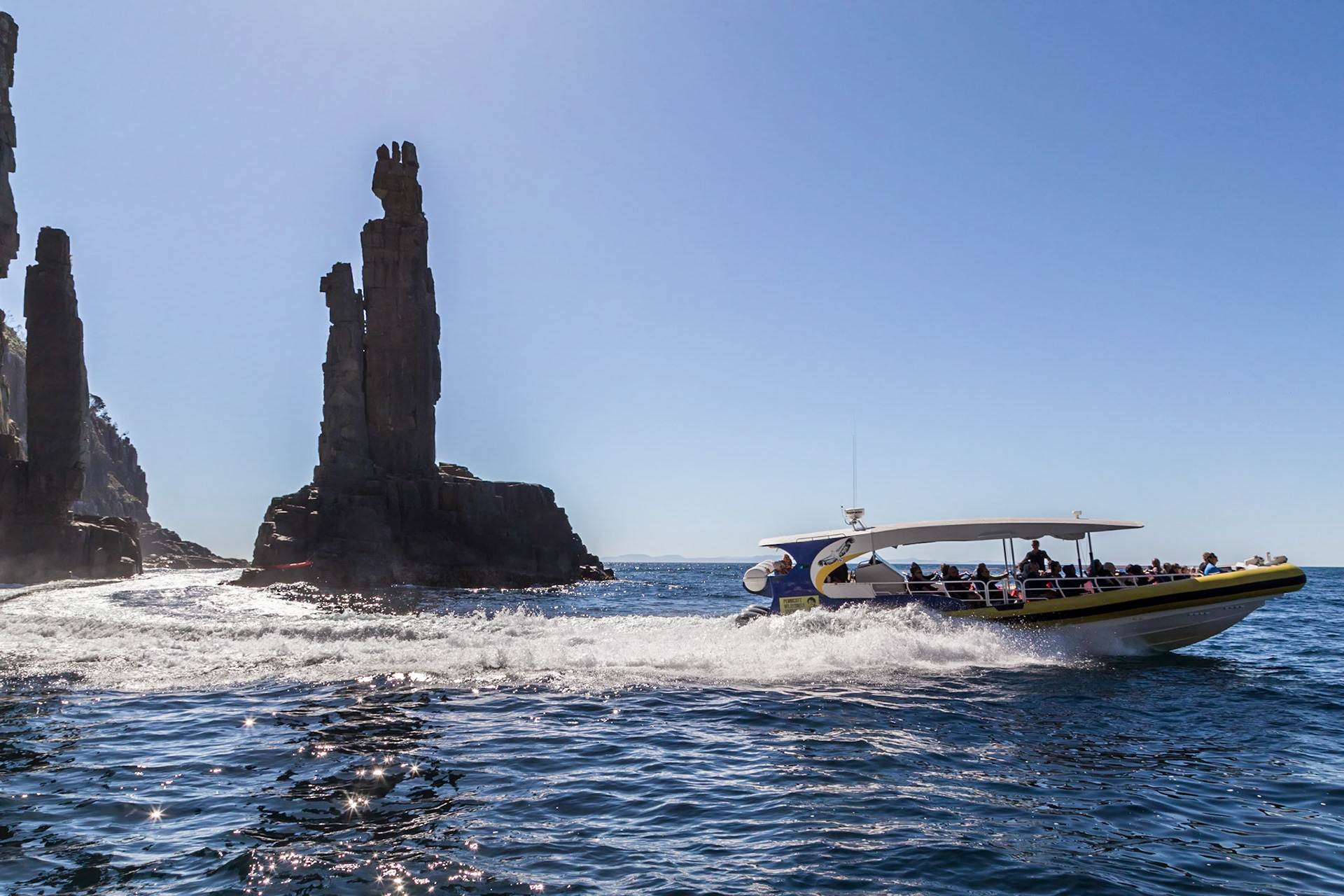 Through the narrow gap between the cliff and 'The Monument' gap. Pennicott Bruny Island Cruises.