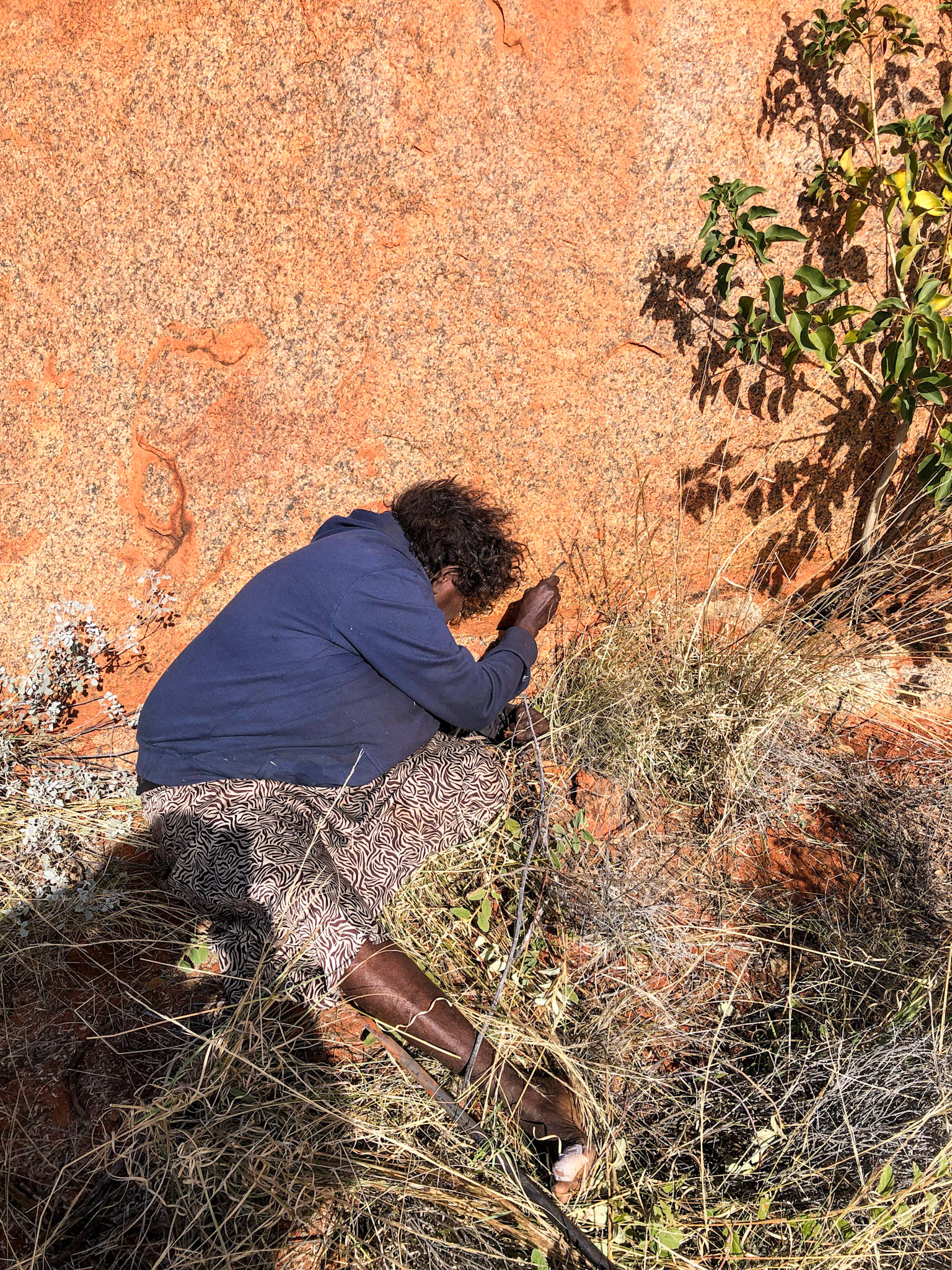 Yukultji prising out a goanna from rock crevice