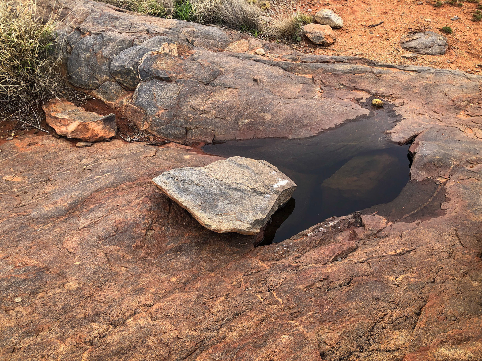 Rock outcrop with ancient water holes and grinding pits.