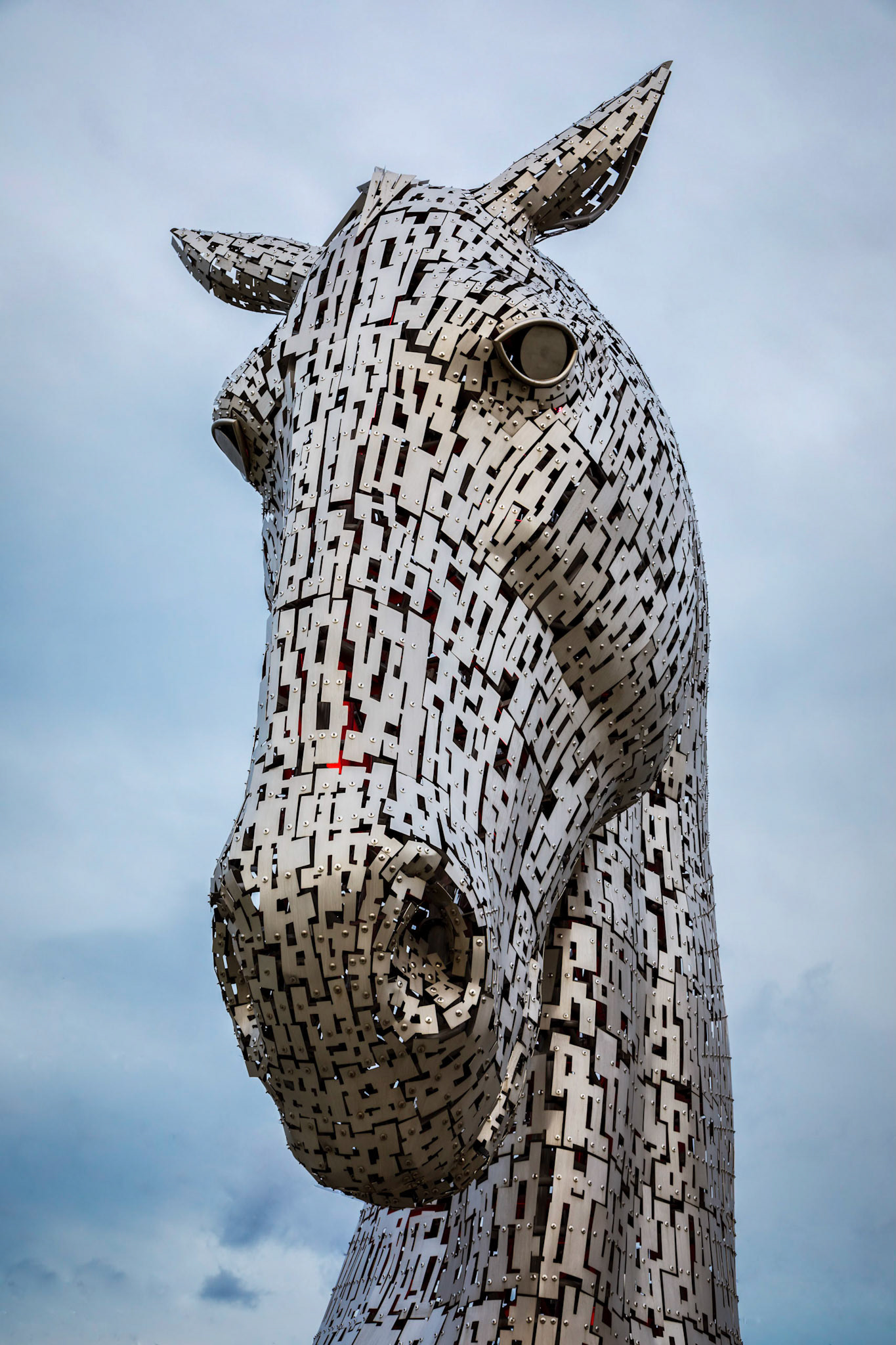 The Kelpies ;  30-metre-high horse-head sculptures featuring kelpies, standing next to a new extension to the Forth and Clyde Canal, and near River Carron, in The Helix, a new parkland project built to connect 16 communities in the Falkirk Council Area, Scotland. The sculptures were designed by sculptor Andy Scott and were completed in October 2013. The sculptures form a gateway at the eastern entrance to the Forth and Clyde canal, and the new canal extension built as part of The Helix land transformation project. The Kelpies are a monument to horse powered heritage across Scotland.