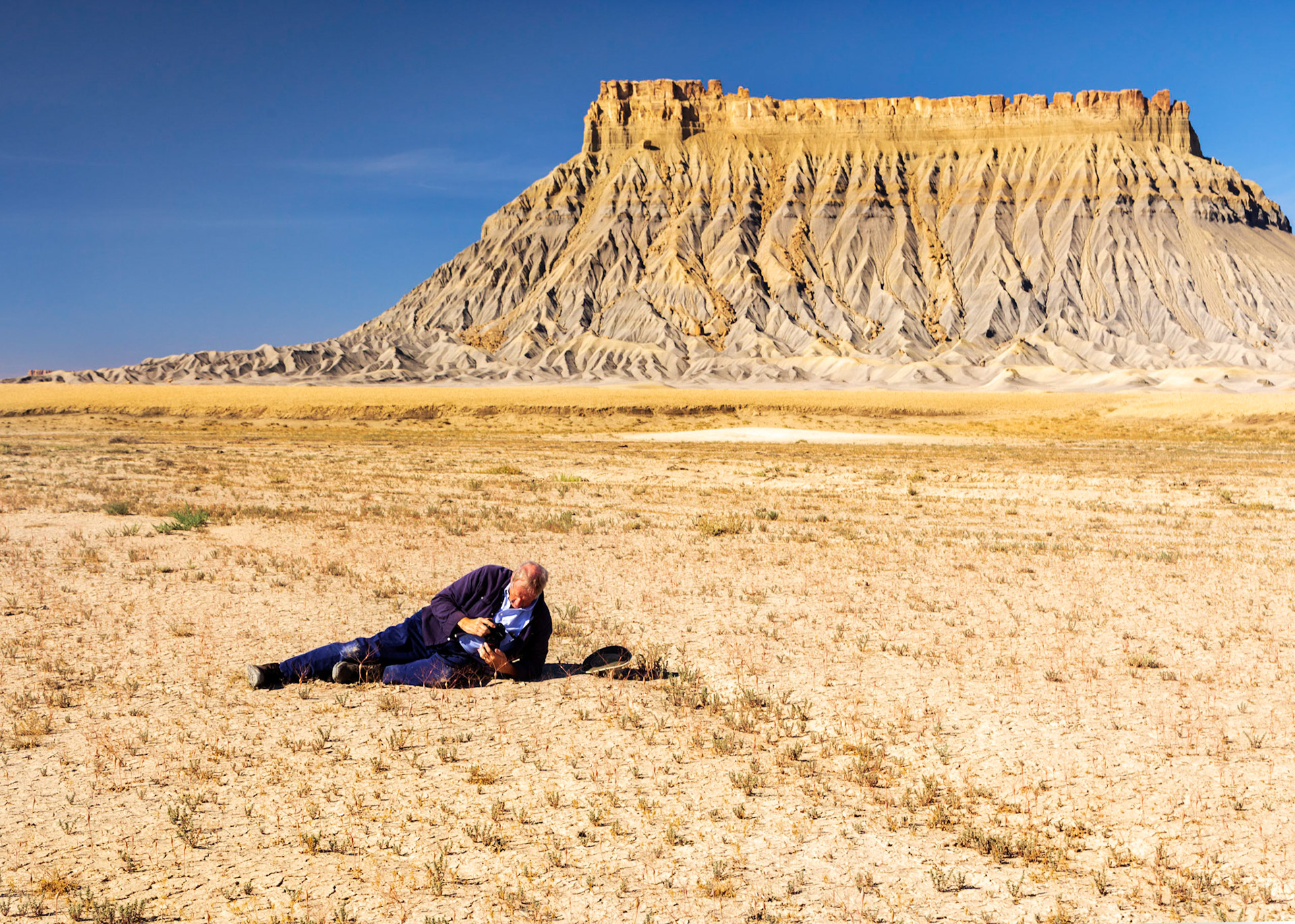 Factory Butte and Greg Smith photographing desert plants.