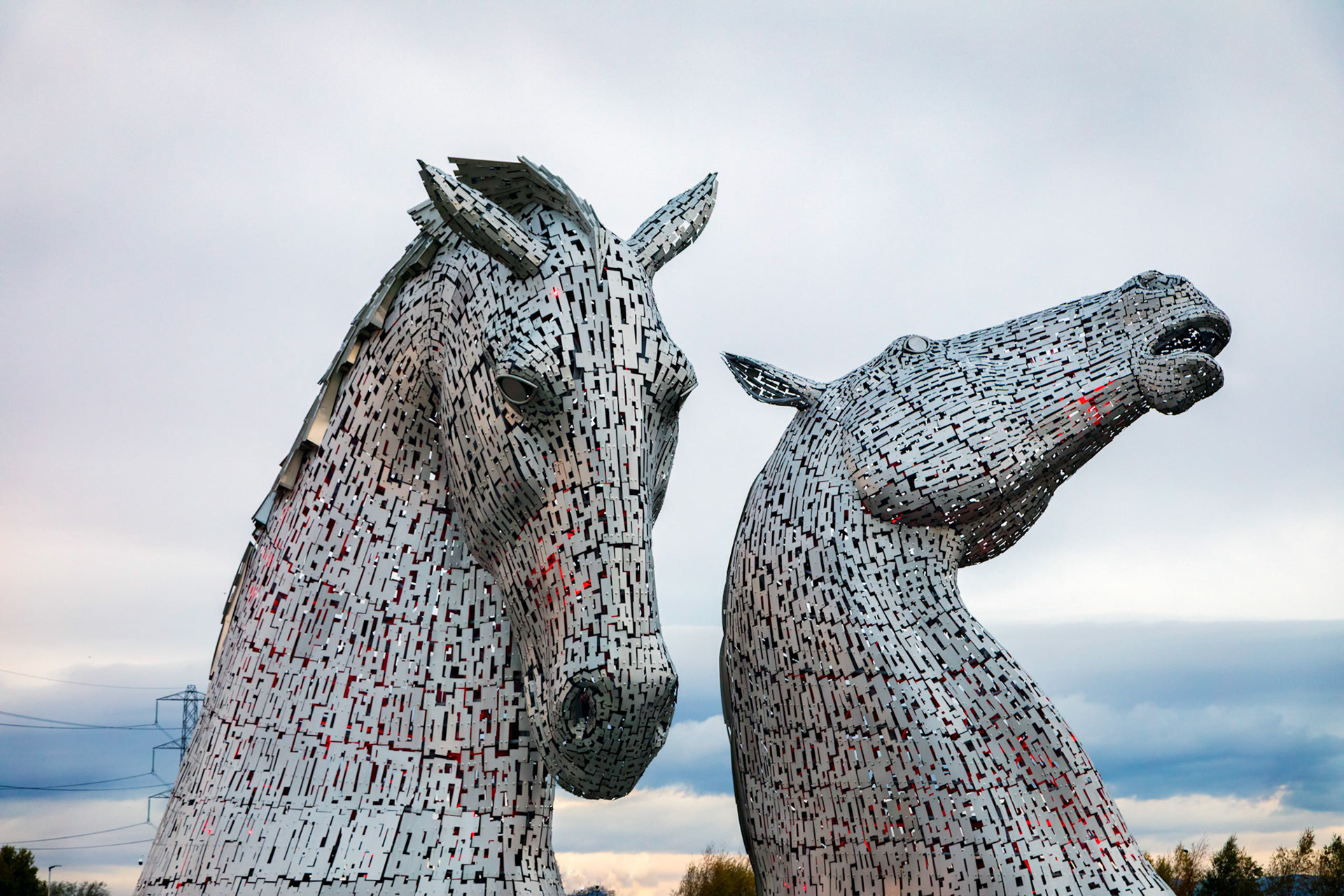 The Kelpies. 30-metre-high horse-head sculptures featuring kelpies, standing next to a new extension to the Forth and Clyde Canal, and near River Carron, in The Helix, a new parkland project built to connect 16 communities in the Falkirk Council Area, Scotland. The sculptures were designed by sculptor Andy Scott and were completed in October 2013. The sculptures form a gateway at the eastern entrance to the Forth and Clyde canal, and the new canal extension built as part of The Helix land transformation project. The Kelpies are a monument to horse powered heritage across Scotland.