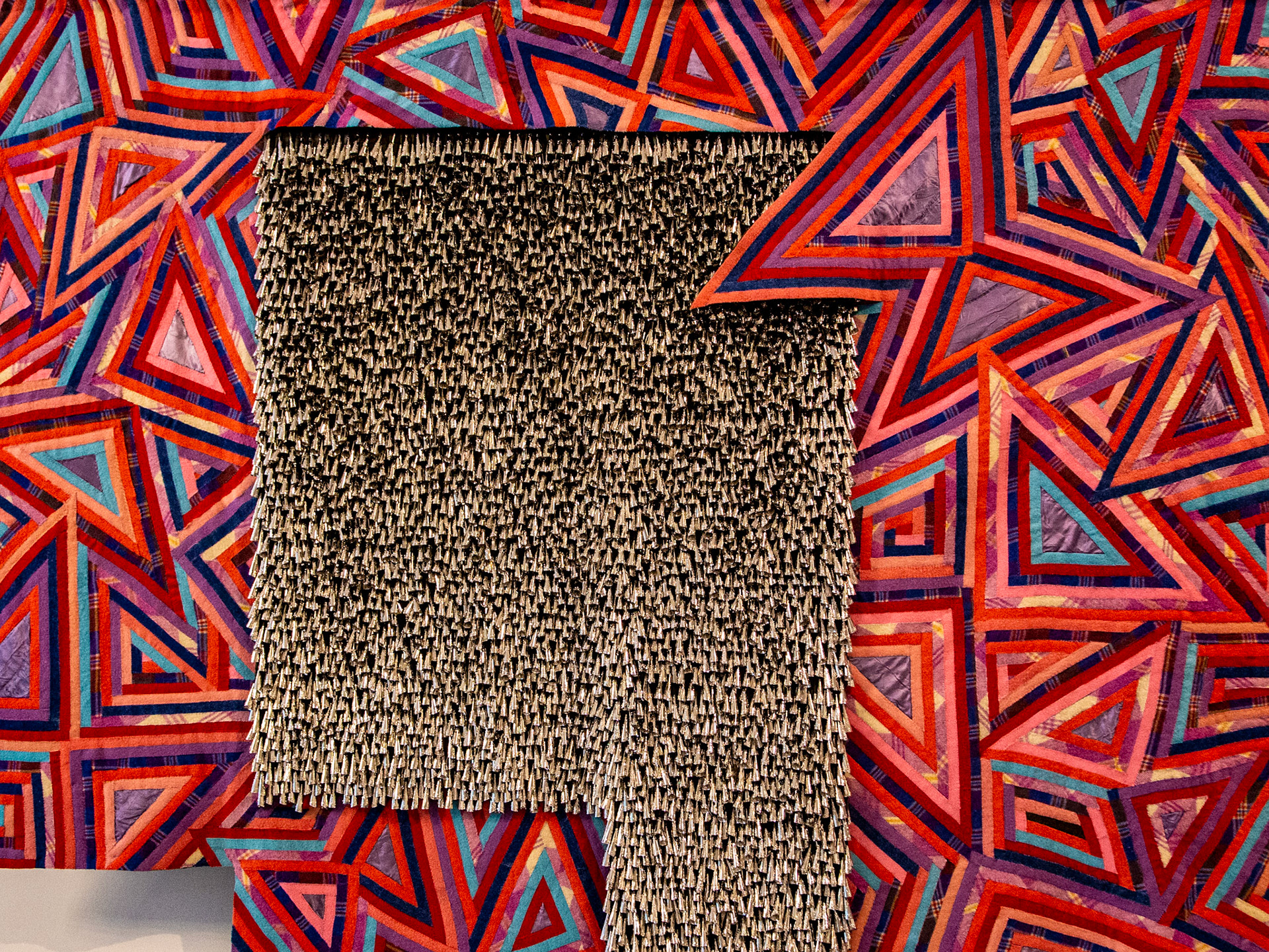 Reclaimed wool blankets, satin binding, thread, cotton twill tape, and tin jingles.