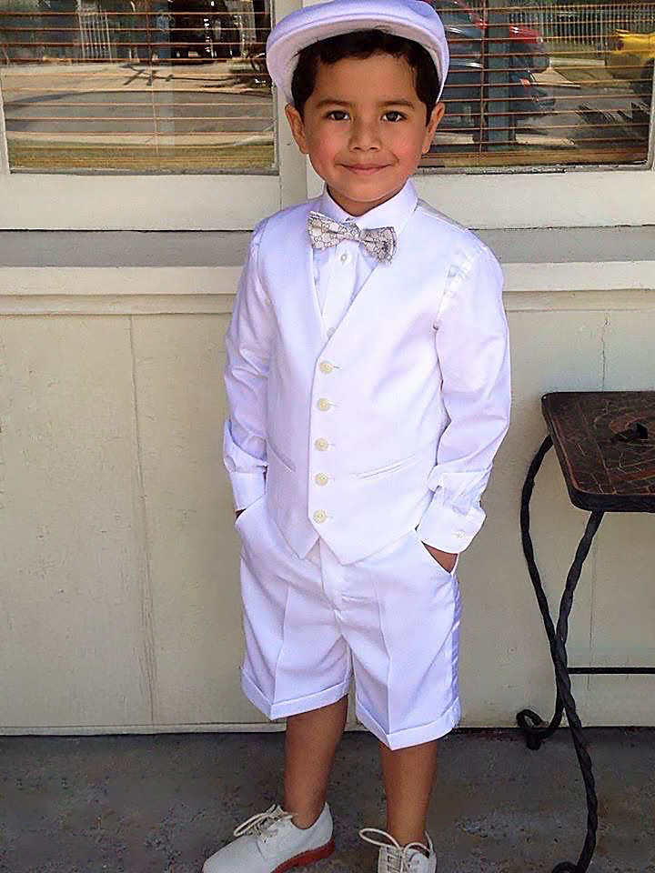 Portrait of a young boy in a white formal outfit and hat, enhanced through Photoshop with color correction, background cleanup, and tonal balancing.
