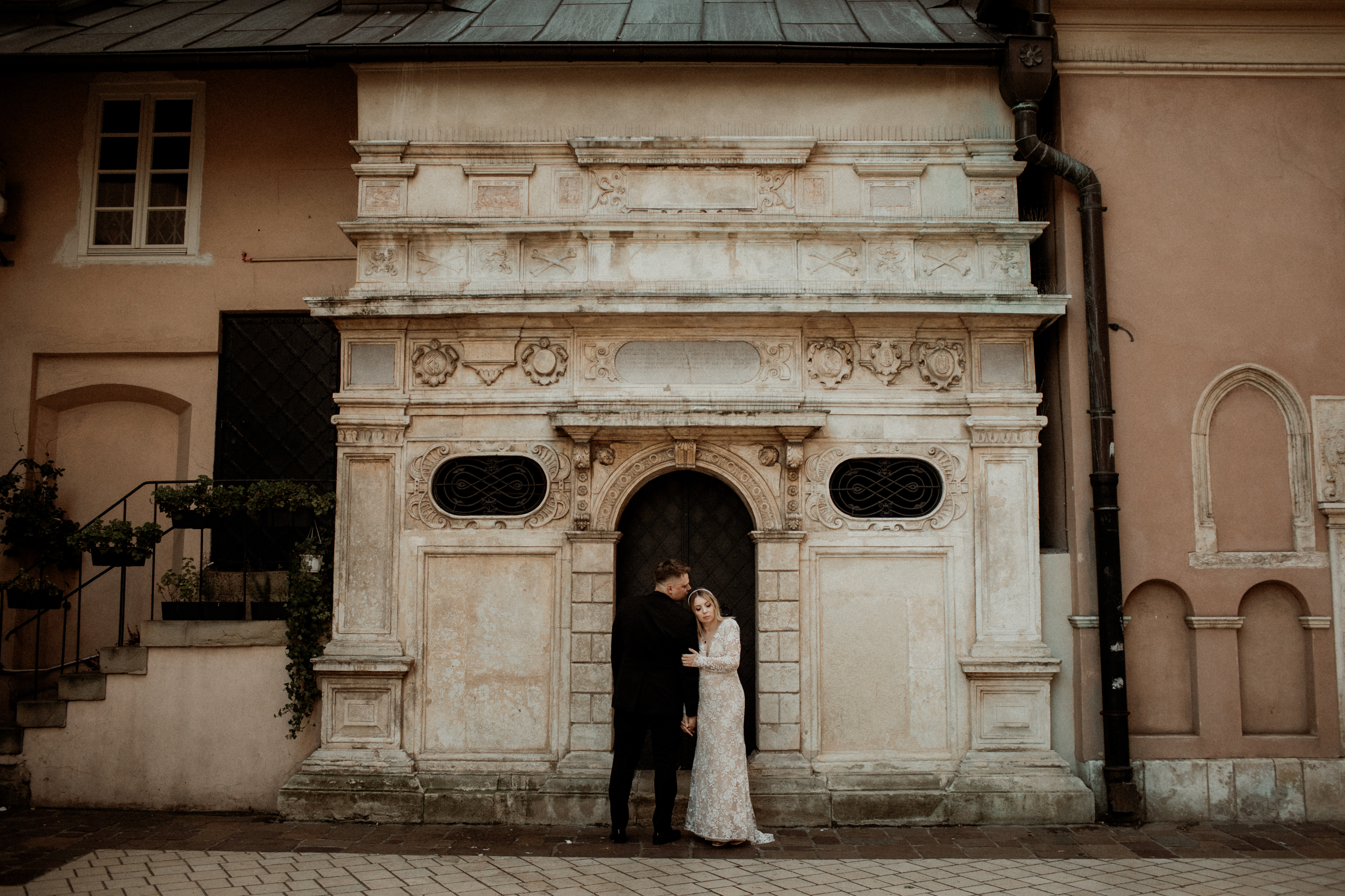 Artystyczna fotografia ślubna – para wśród kamienicy w mieście