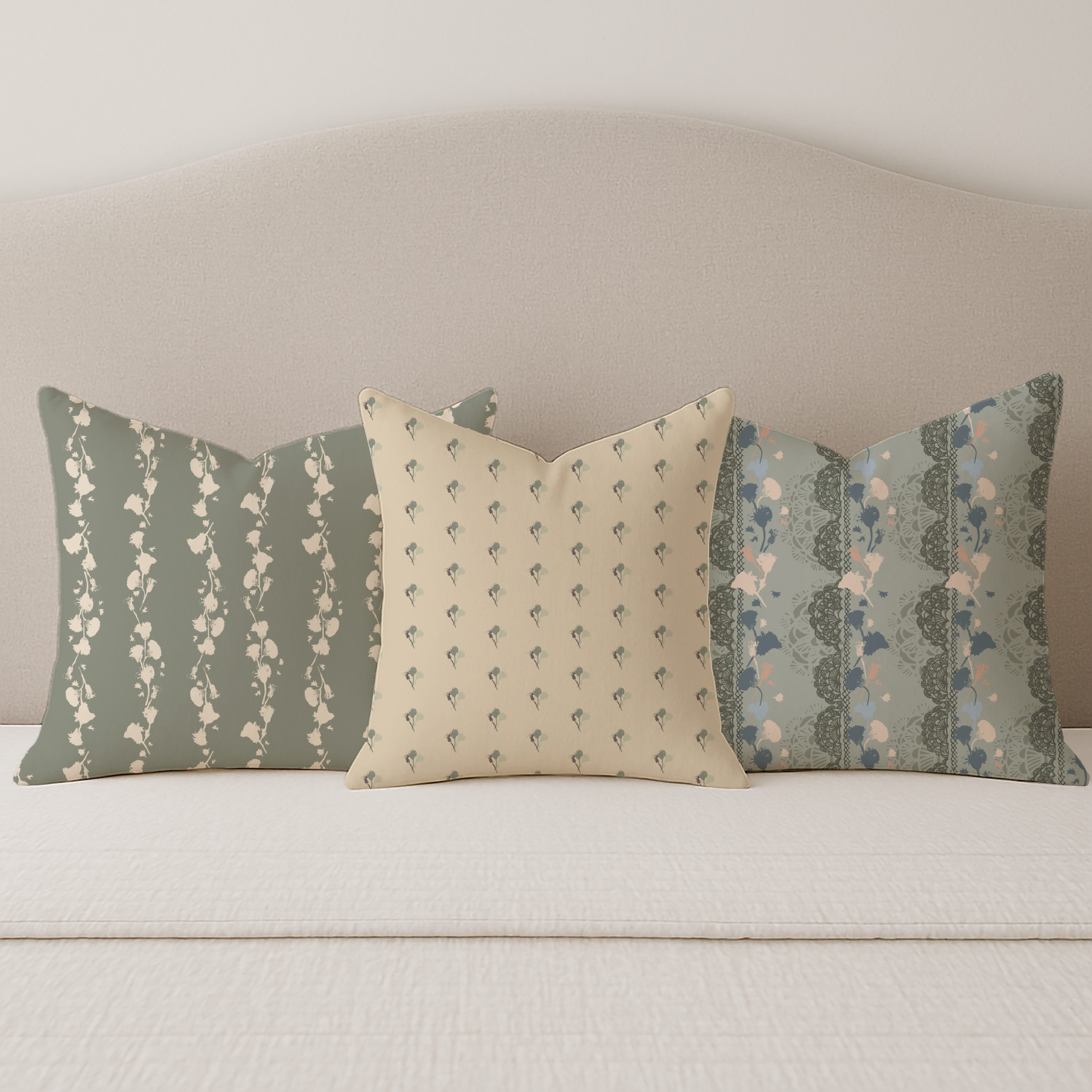 Cushion trio featuring Heirloom Cottage designs in soft green tones, including vintage‑style florals, coordinating sprigs, and gentle ditsy floral patterns arranged on a neutral sofa.