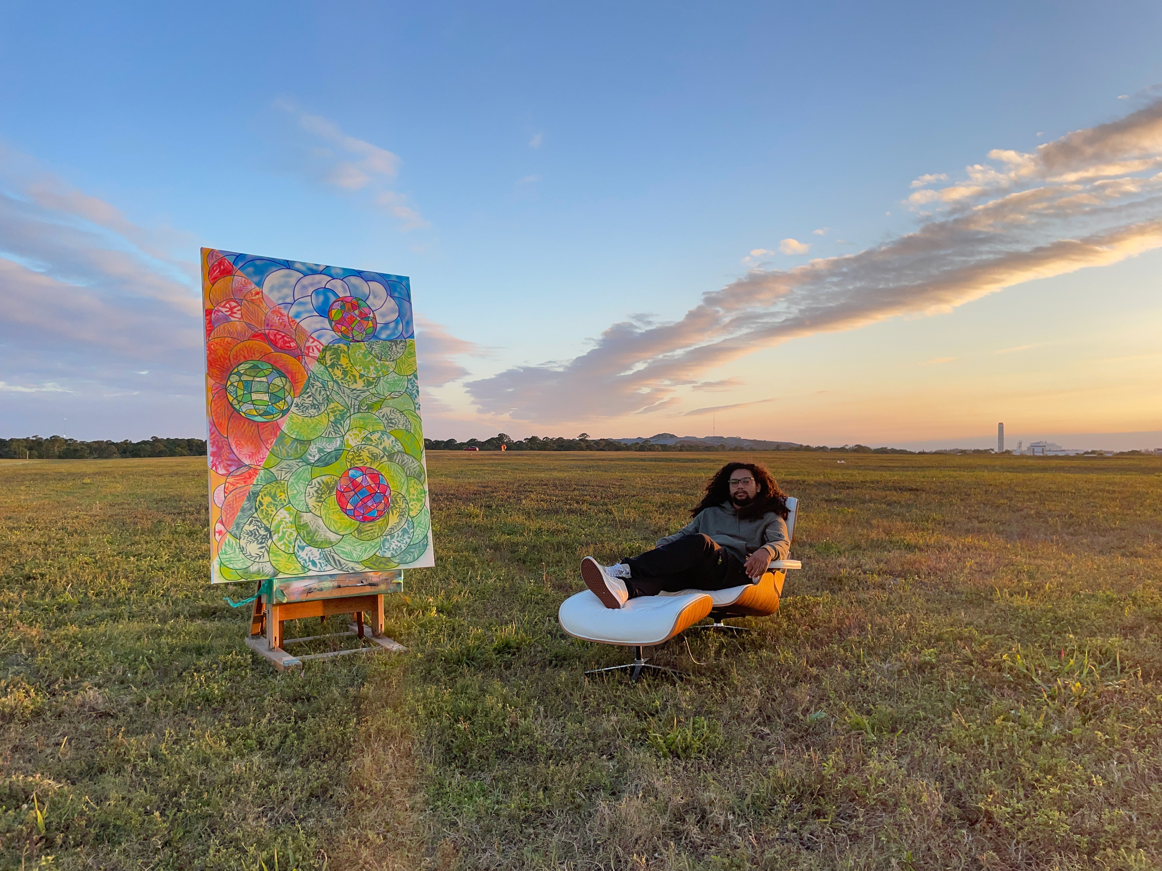 Timi Ogundipe (b.1990) is a South Florida based abstract and contemporary street artist whose works range from paintings to murals. His mark has been made in many cities across the globe such as New York CIty, Berlin, Paris, Boston, Miami, and Barcelona. Known for his hand drawn circles and deconstructed graffiti, using plant flora from his surroundings, he sources inspiration from music, science and nature blending them into compositions consisting of eccentric cyphers, plant stencils, fine lines, obtuse and acute shapes. Fossilizing plant life onto his works, inspired by the stencils of Cueva de las Manos, & the abstract expressionist movement, he saturates his work in layers of rich colors as he composes moments of time into his pieces. Attempting to soothe himself and the viewer, he creates works that hold the energy of a bouquet of flowers. With an affinity for graffiti, quantum theory and Earth’s rich terrain he explores inward to express outward and find a balance in the styles he’s found peace in.