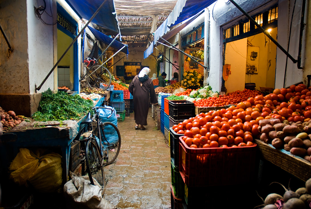 A woman walking in a Essaoira's vegetables market.