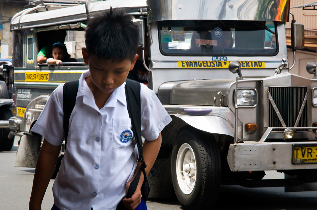  A boy going to school in the streets of Manila. 