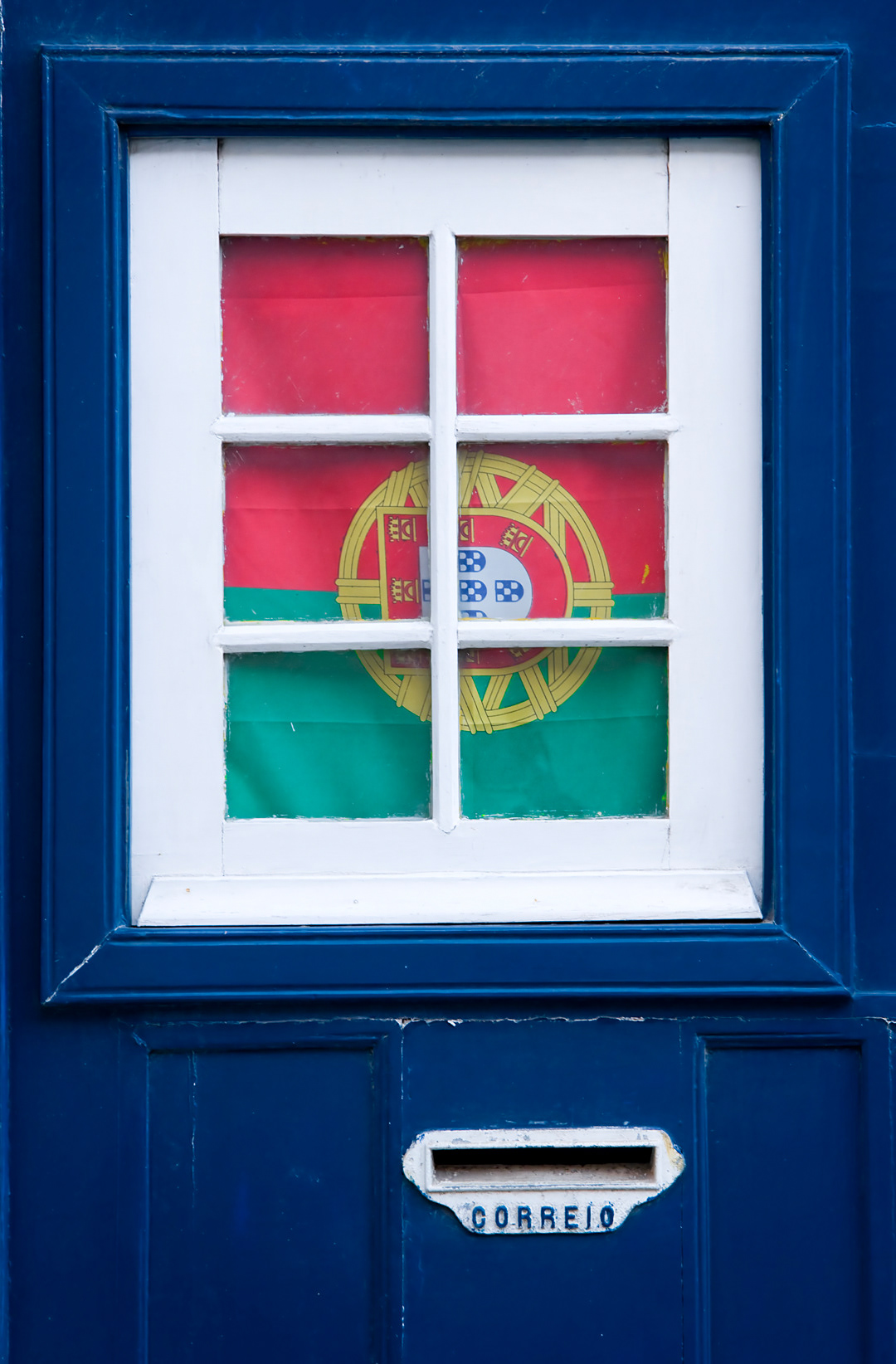 Portuguese flag on the door of a house in the Alfama district of Lisbon. 