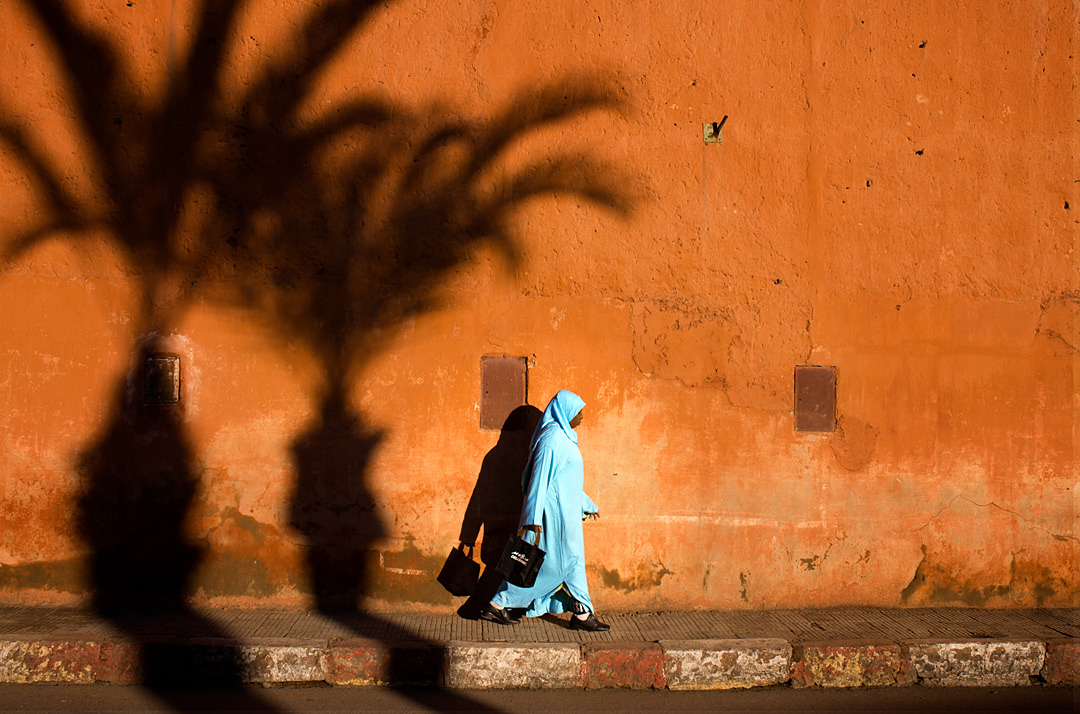 A woman walking beside the Marrakech walls.