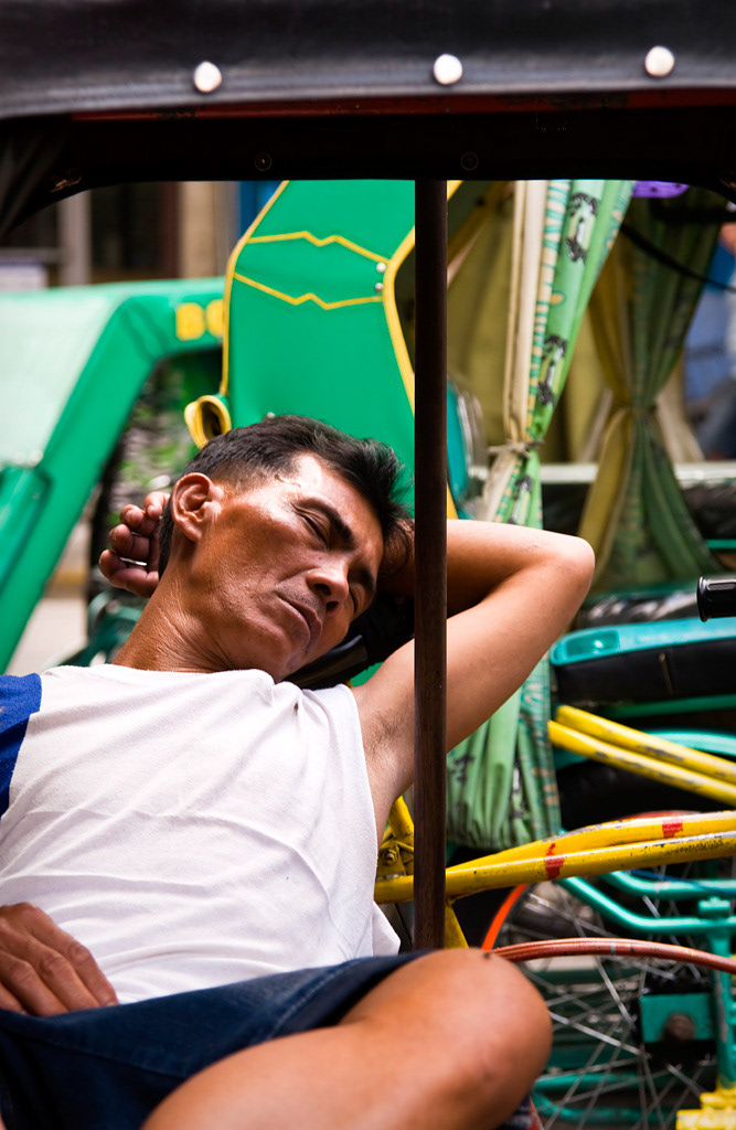 Manila.  Tricycle´s driver sleeping in his vehicle. 