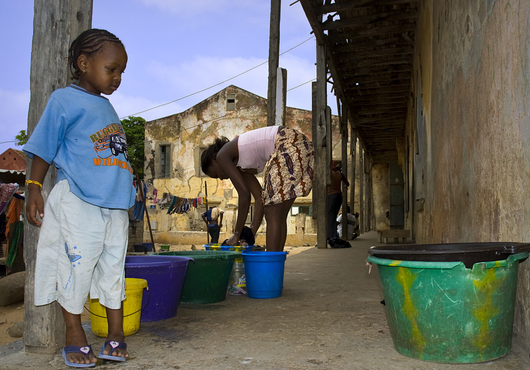 A woman washing clothes on the porch of a house in Goree. 