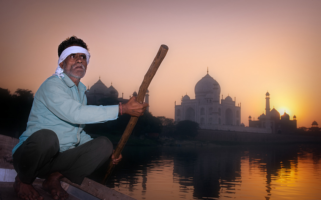 Agra, boatman in the Yamuna river and Taj Mahal at sunset.