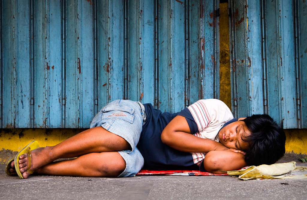  A homeless girl sleeping in the streets of Manila. 