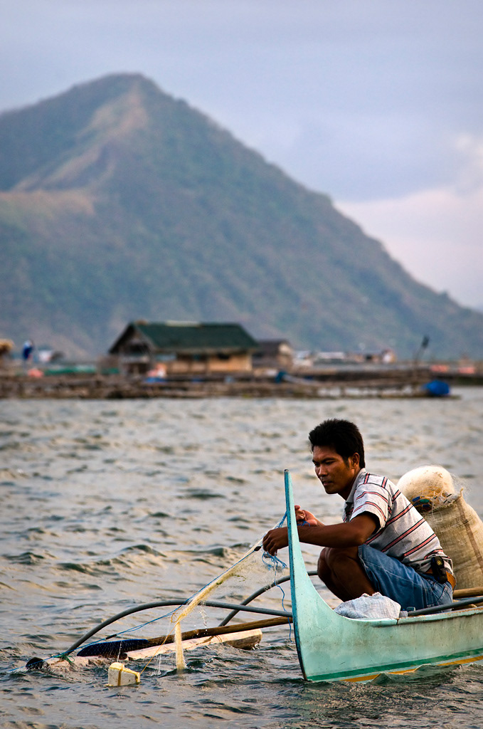 Fisherman in lake Taal with Taal vulcano in the background.